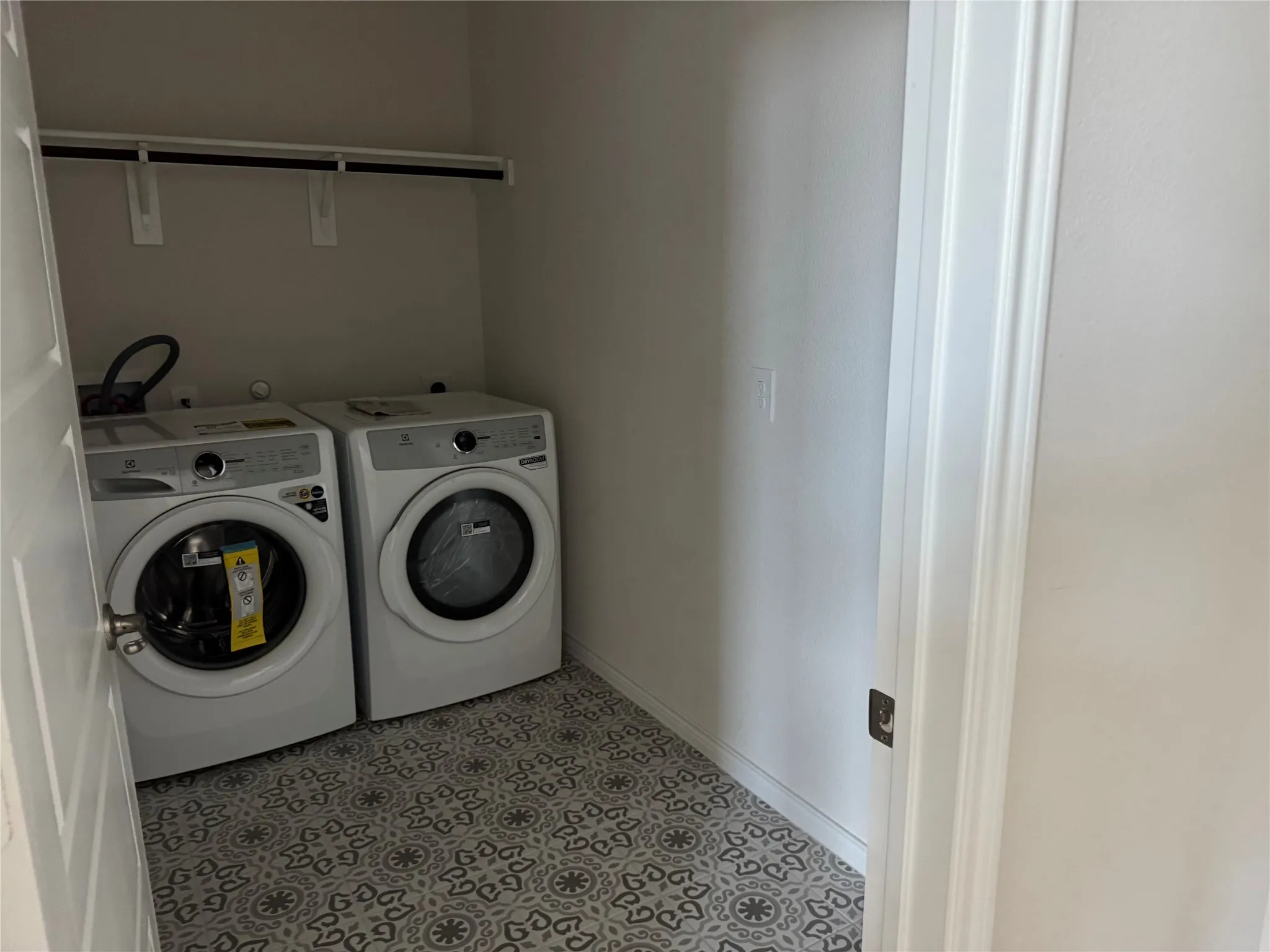 Utility area featuring patterned tile flooring and an integrated shelving unit