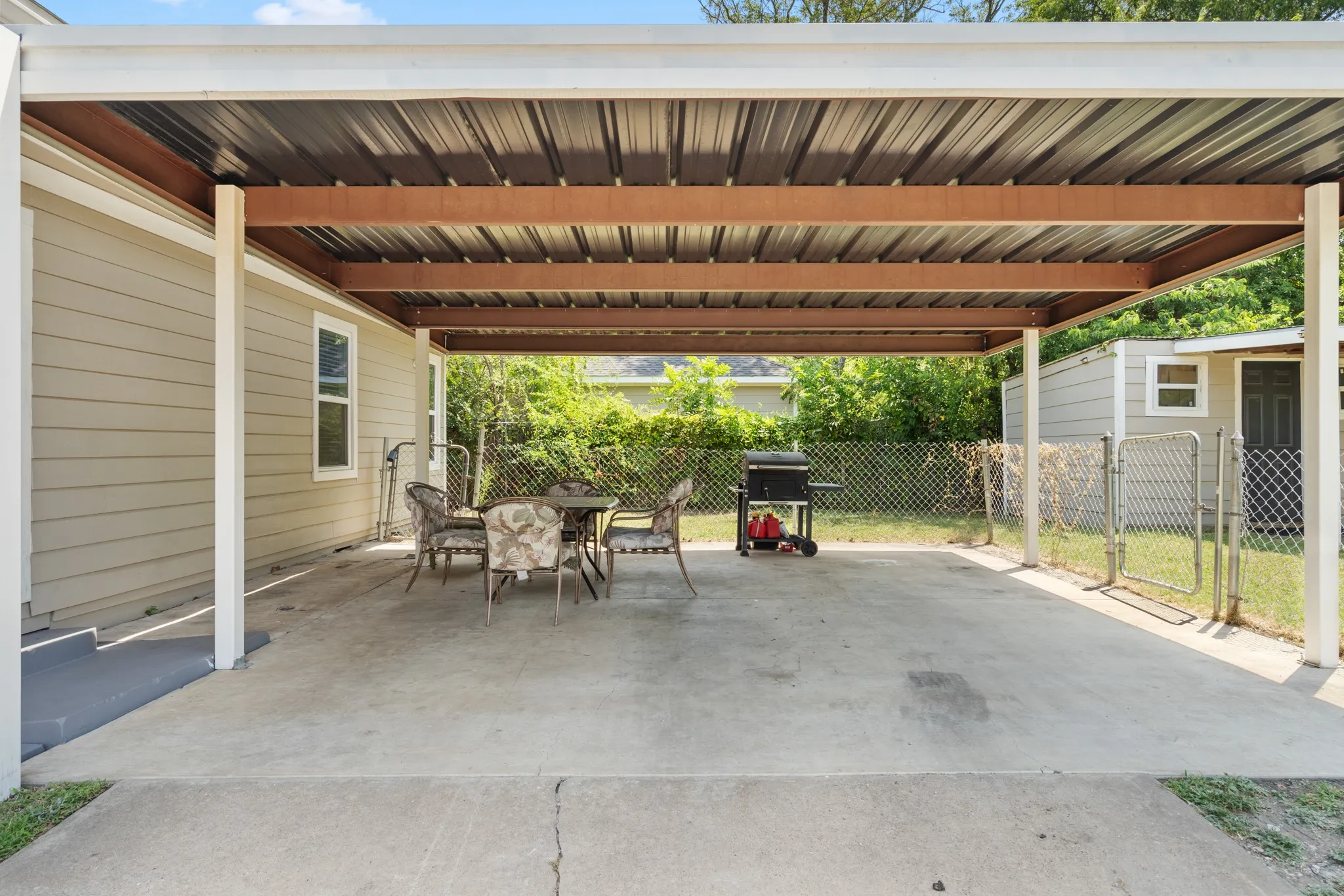 Generous covered carport and patio area offers flexible use for parking, grilling, entertaining or shaded outdoor living, with convenient access directly into the home.