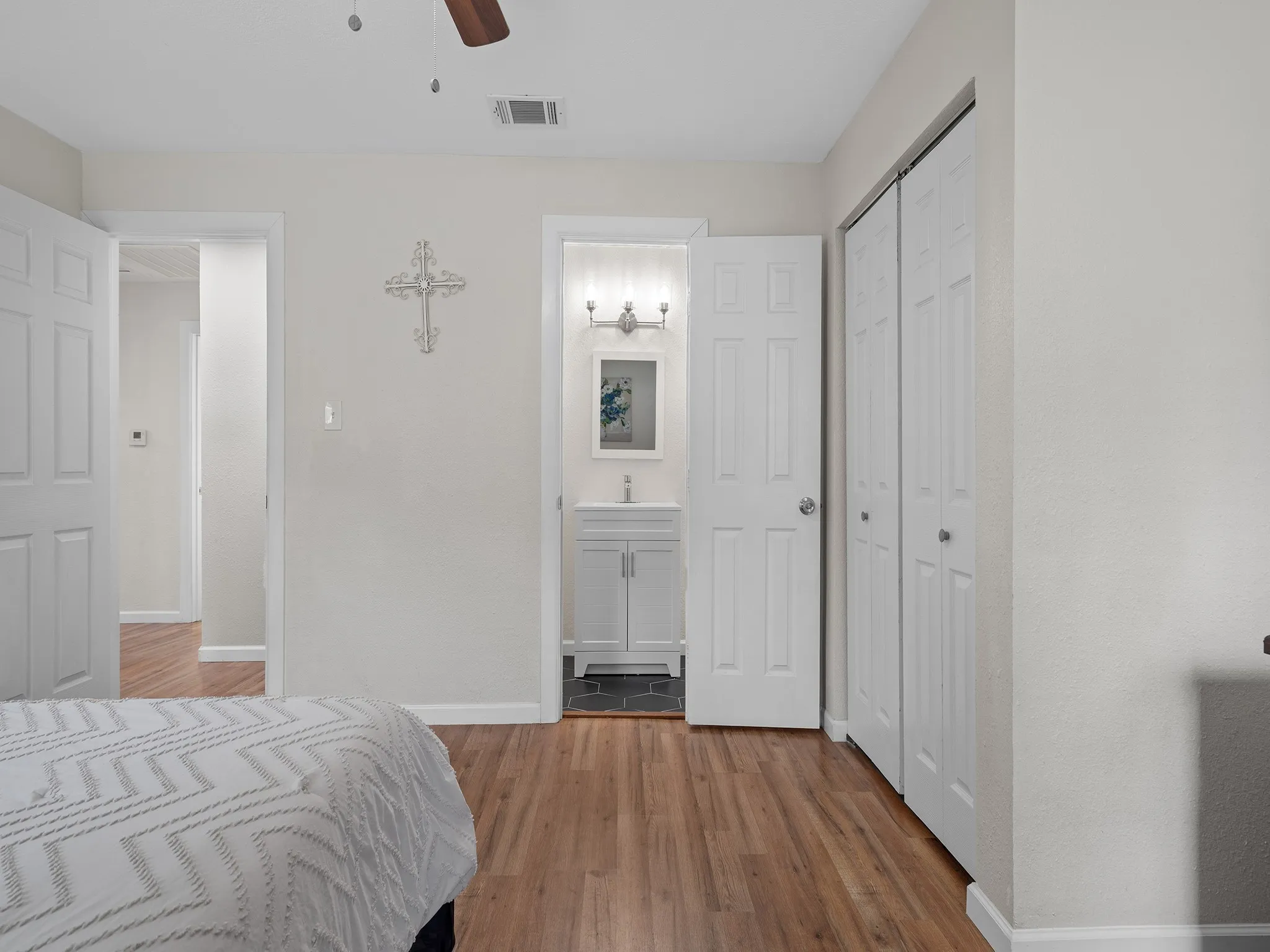 Primary bedroom features smooth vinyl flooring, a generous closet, and a convenient private en-suite bath—creating a comfortable and functional owner’s retreat.