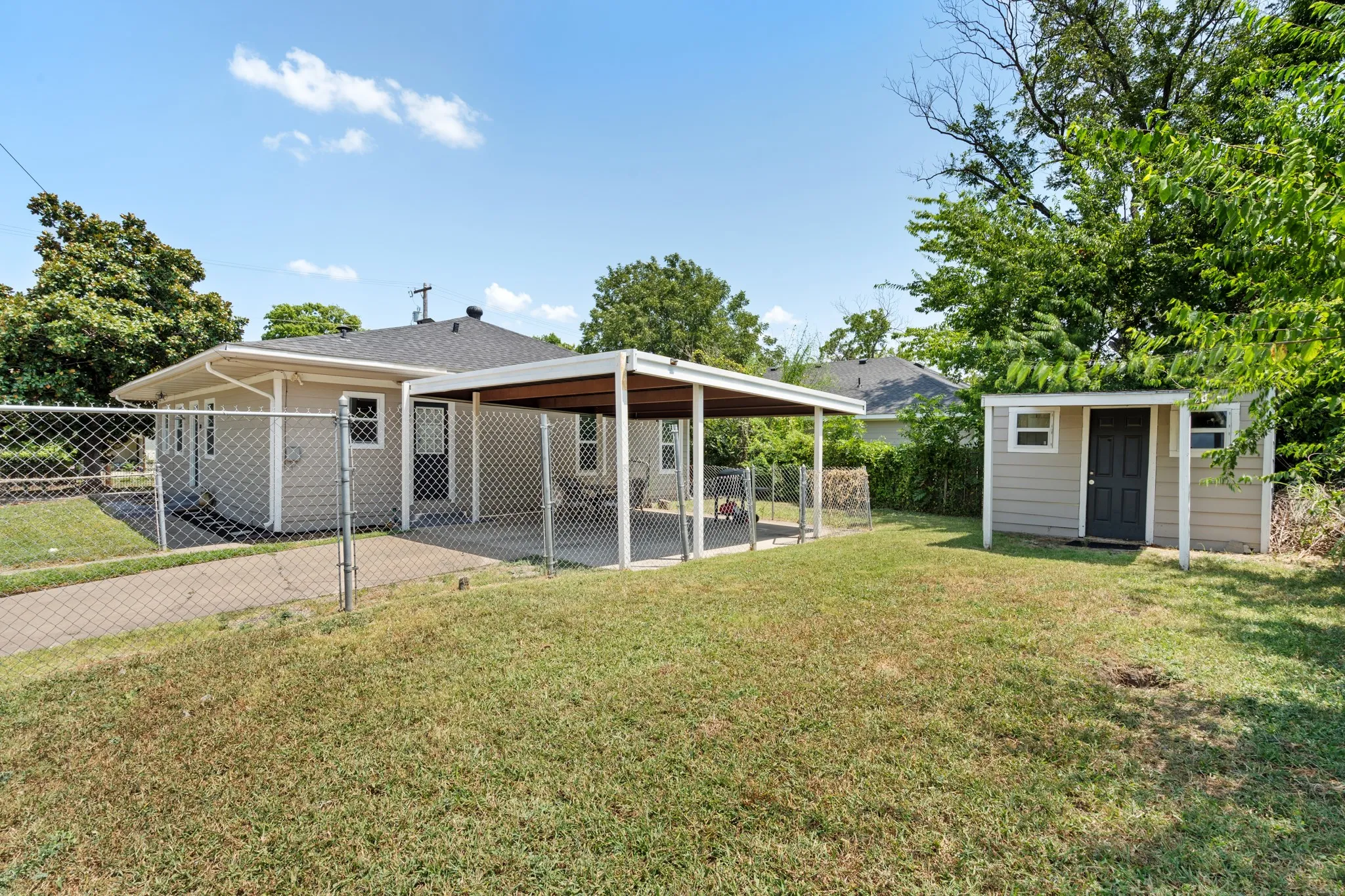 Dual-driveway setup adds flexibility with covered carport parking and room for outdoor living. Fully fenced corner lot provides added privacy, while the extended concrete area offers plenty of space for parking, grilling, relaxing or entertaining.