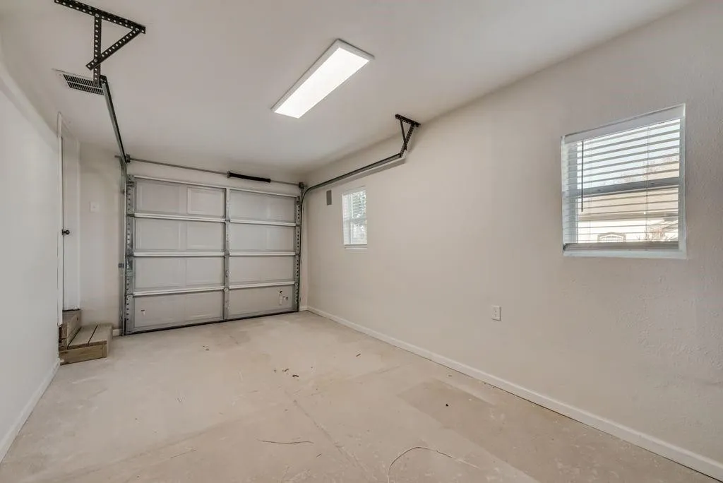 Spacious enclosed garage with interior lighting and room to customize for parking, storage, projects or a versatile flex area to fit your needs.