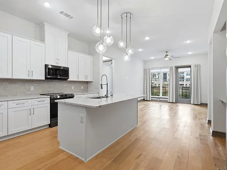 Bright open-concept kitchen with white cabinetry, stainless steel appliances, and a central island