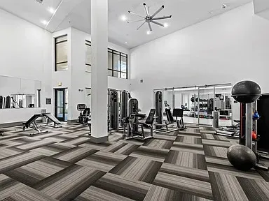 Fitness center featuring high ceilings, contemporary patterned carpet, and extensive workout equipment