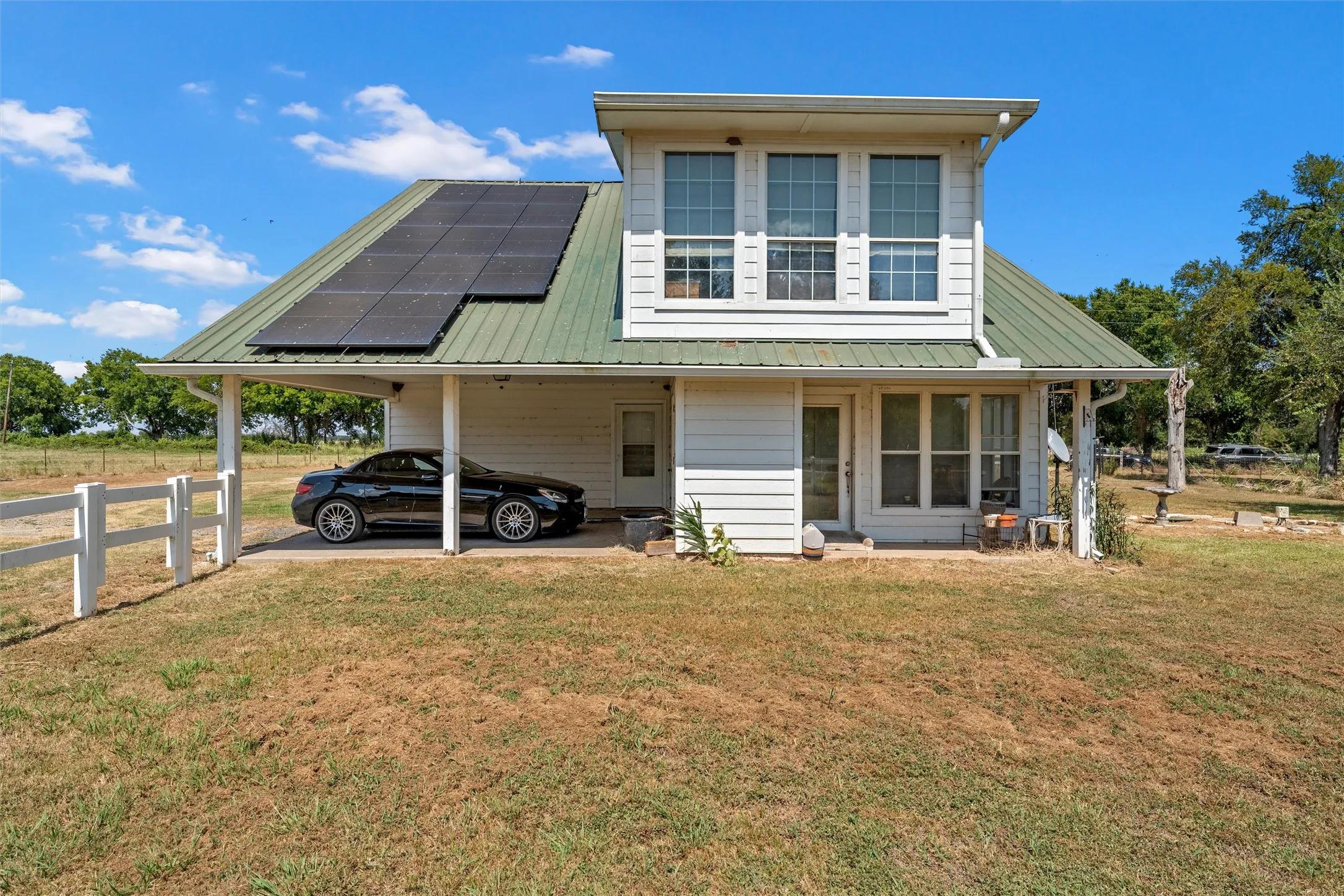 Back of main home featuring attached car port