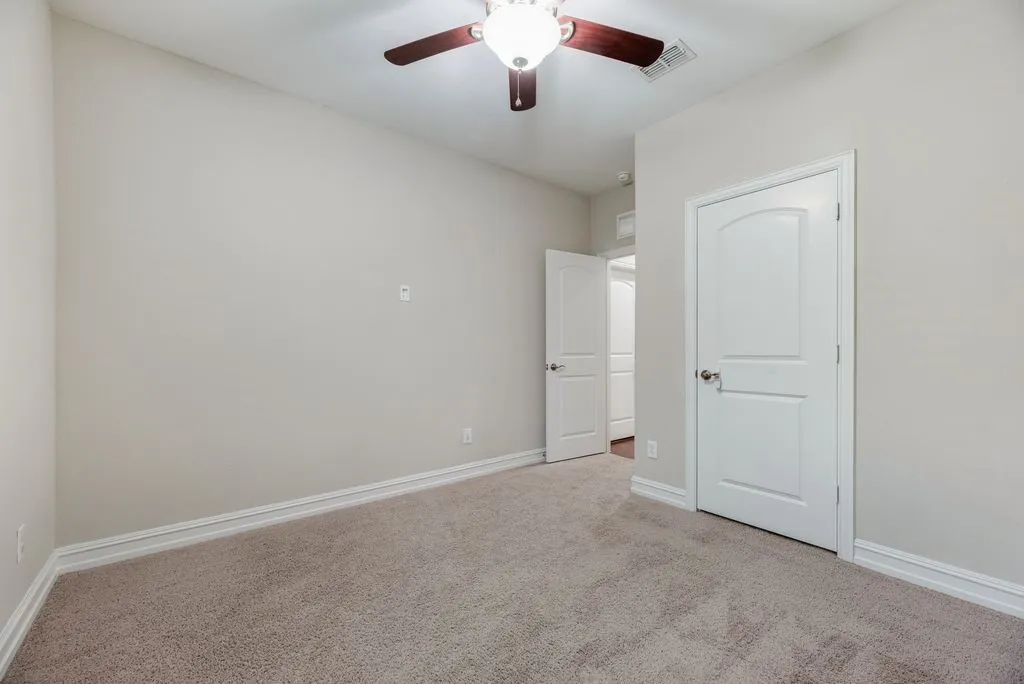 Bedroom 4 - Neutral paint palette, ceiling fan with light fixture, carpet flooring, arched panel interior doors, crown molding