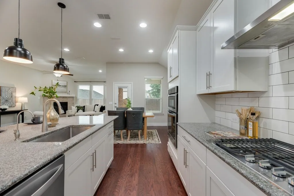 Kitchen featuring stainless steel appliances, white cabinetry, and granite countertops