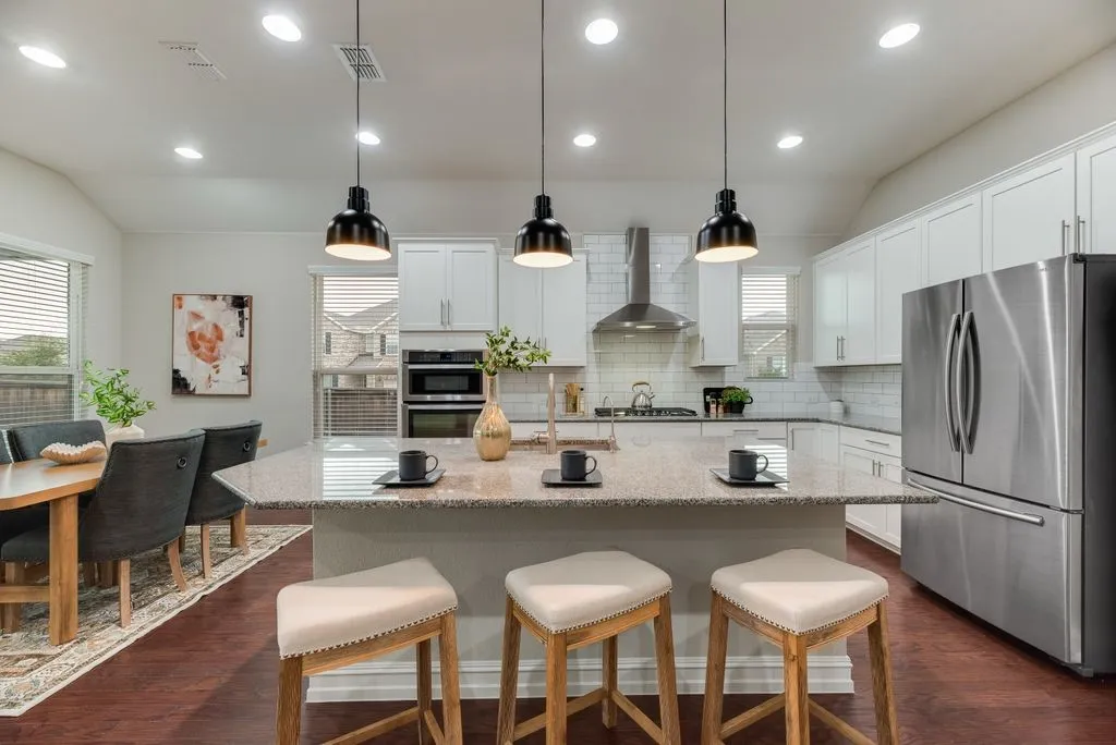 Kitchen with a central island, recessed lighting, pendant light fixtures, stainless steel appliances, and white cabinetry