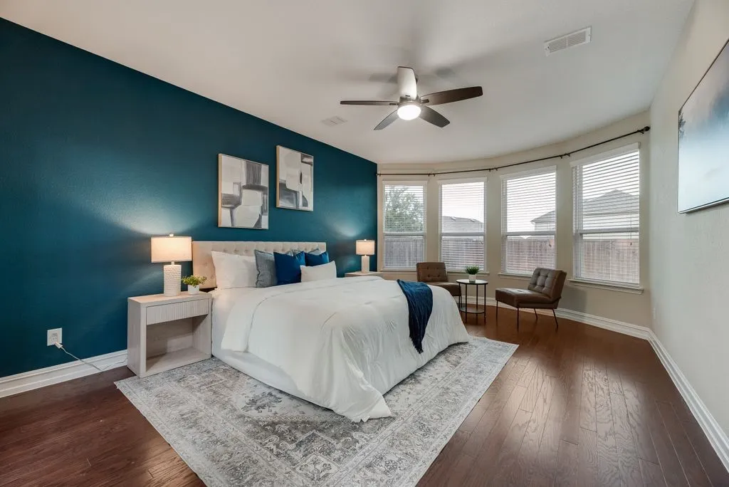 Wood-finish flooring throughout, curved window wall with multiple windows, ceiling fan, and recessed lighting