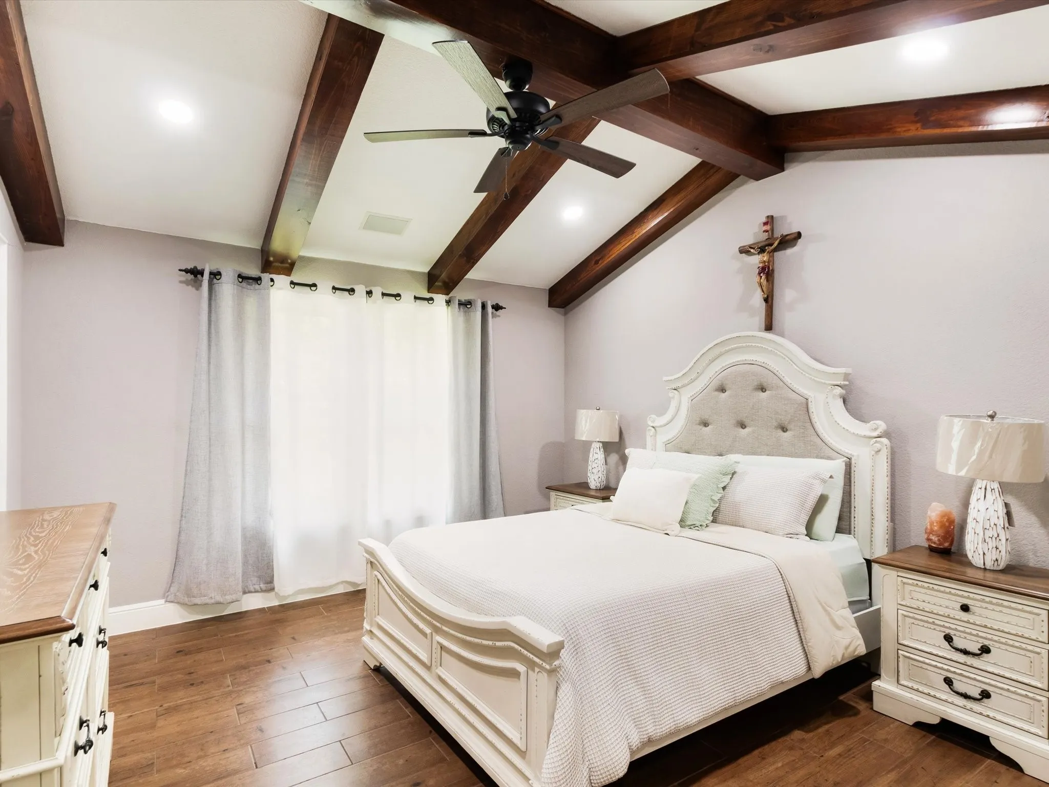 Vaulted ceiling with exposed wood beams, ceiling fan, recessed lighting, and wood-finish flooring