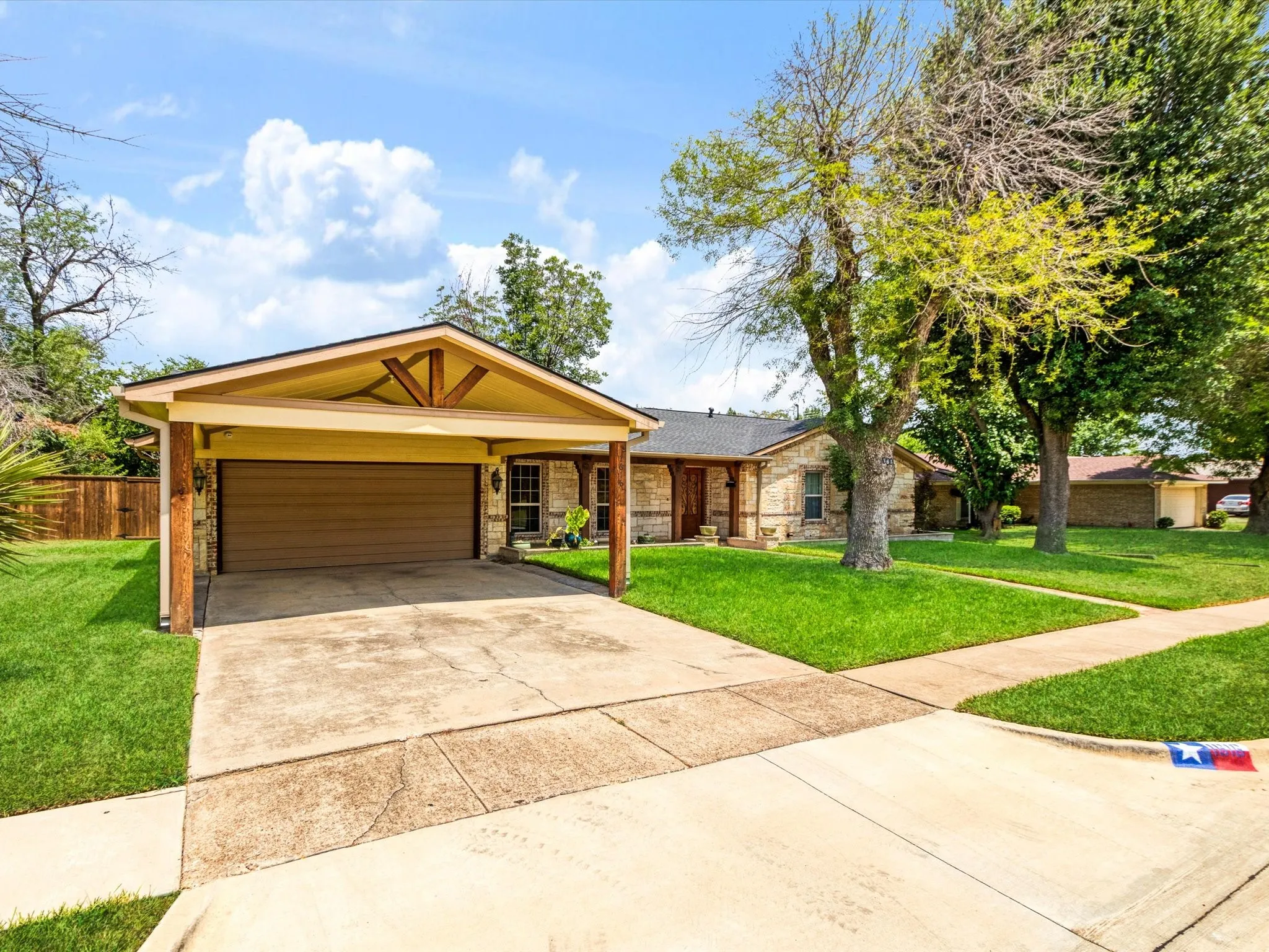 Stone facade with a prominent carport featuring wood-beamed accents