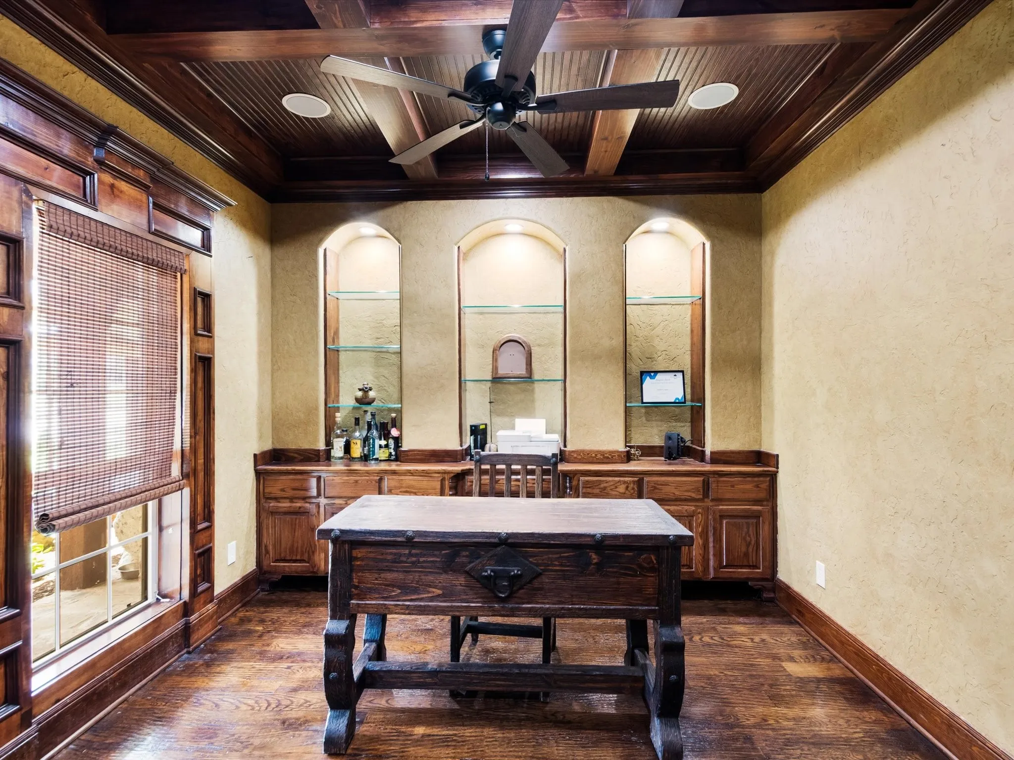 Wood-finish flooring, built-in cabinetry, and ceiling fan with integrated lighting