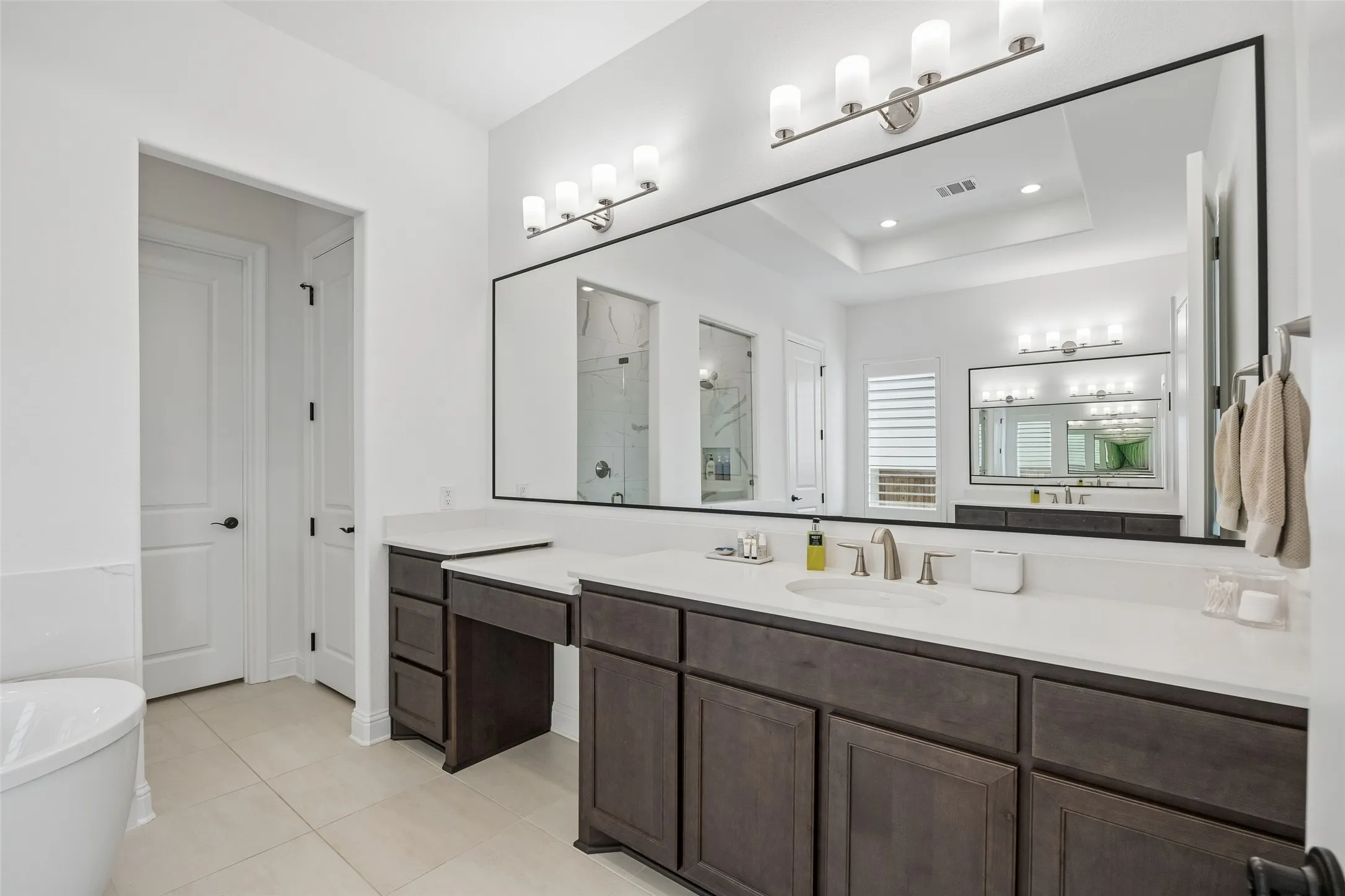 Dual vanity with white countertops and dark wood-finish cabinetry