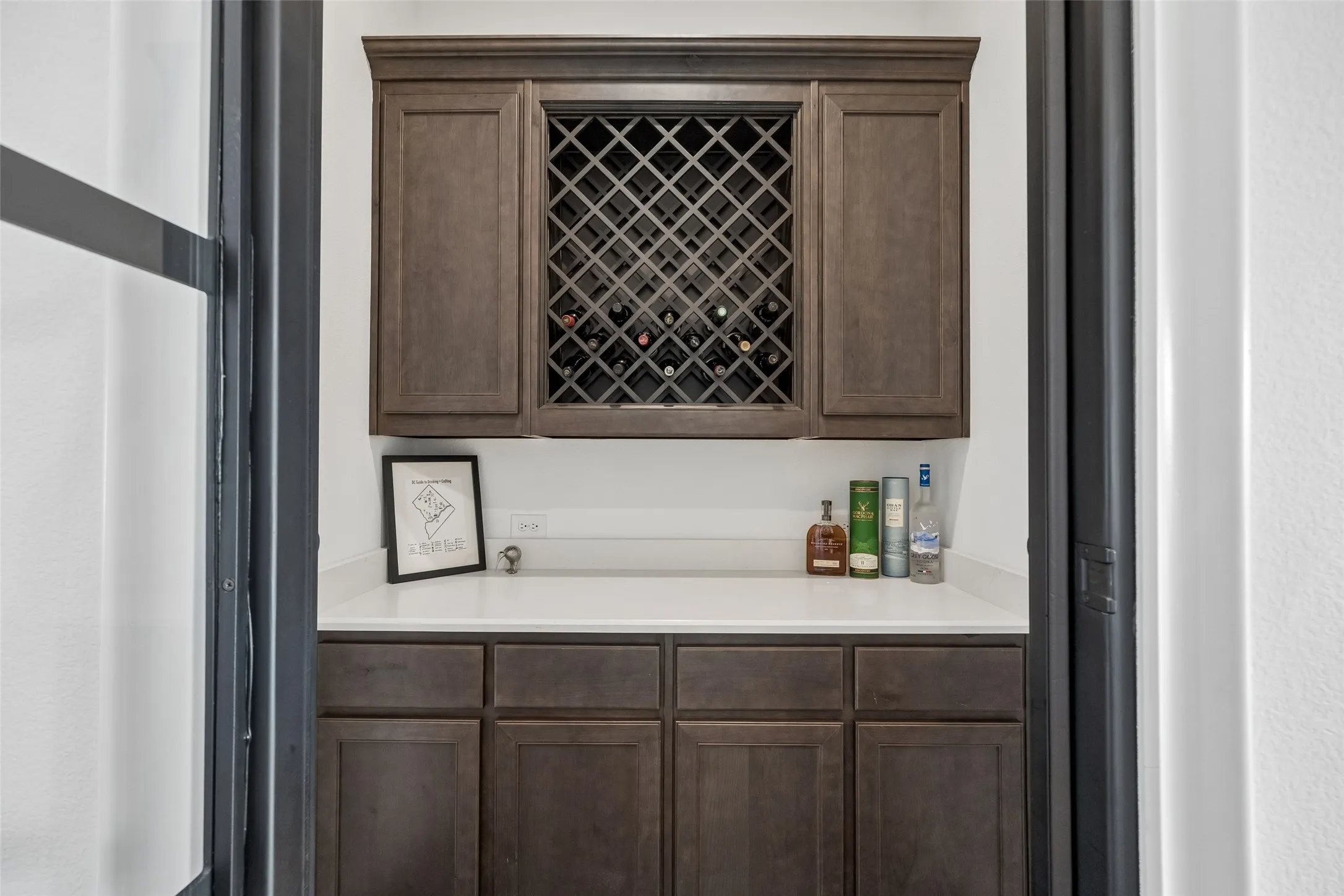 Built-in cabinetry with wood-finish doors, a full-height wine rack, and a light-toned countertop