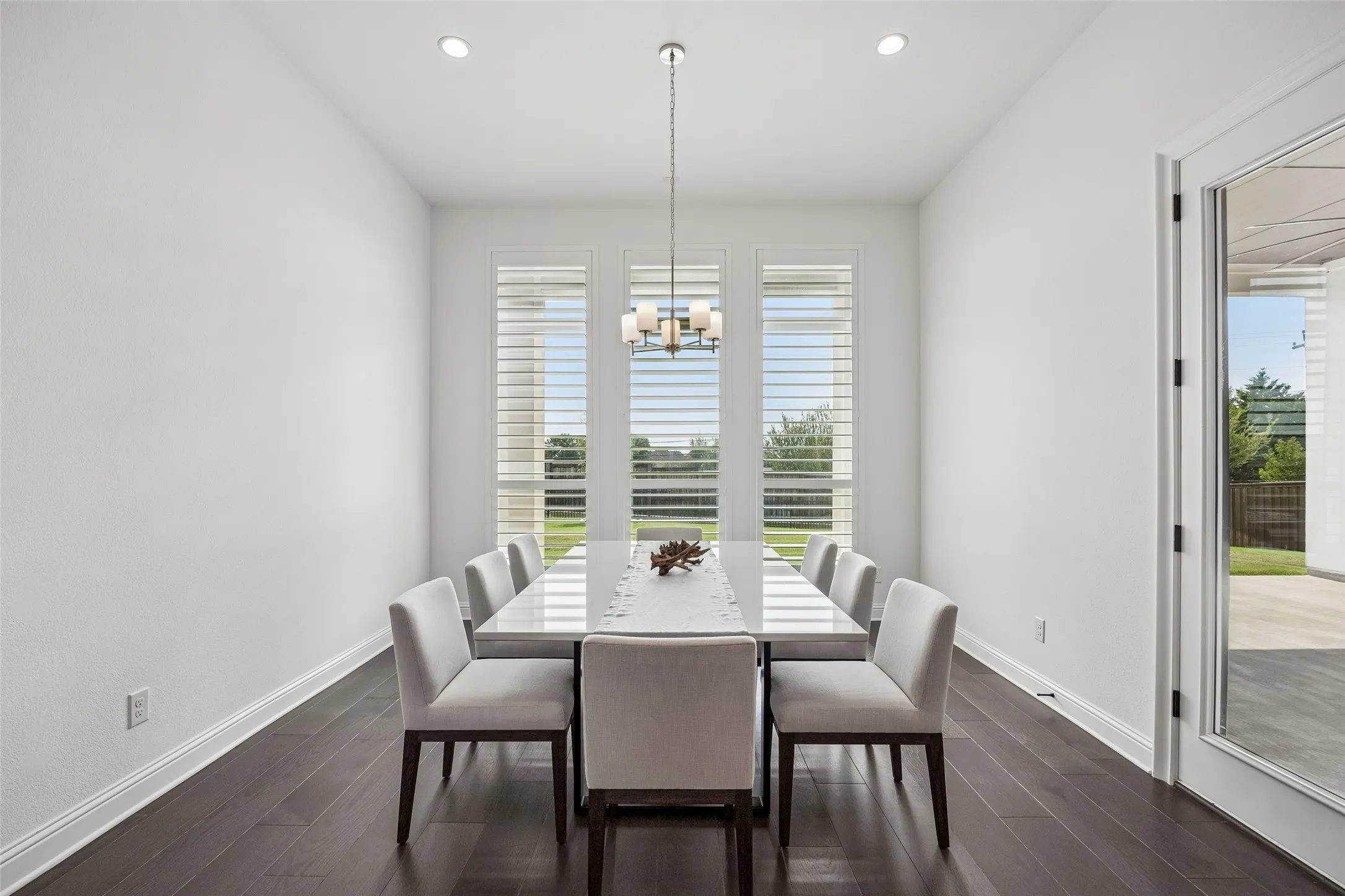 Recessed lighting, wood-finish flooring, and a contemporary chandelier