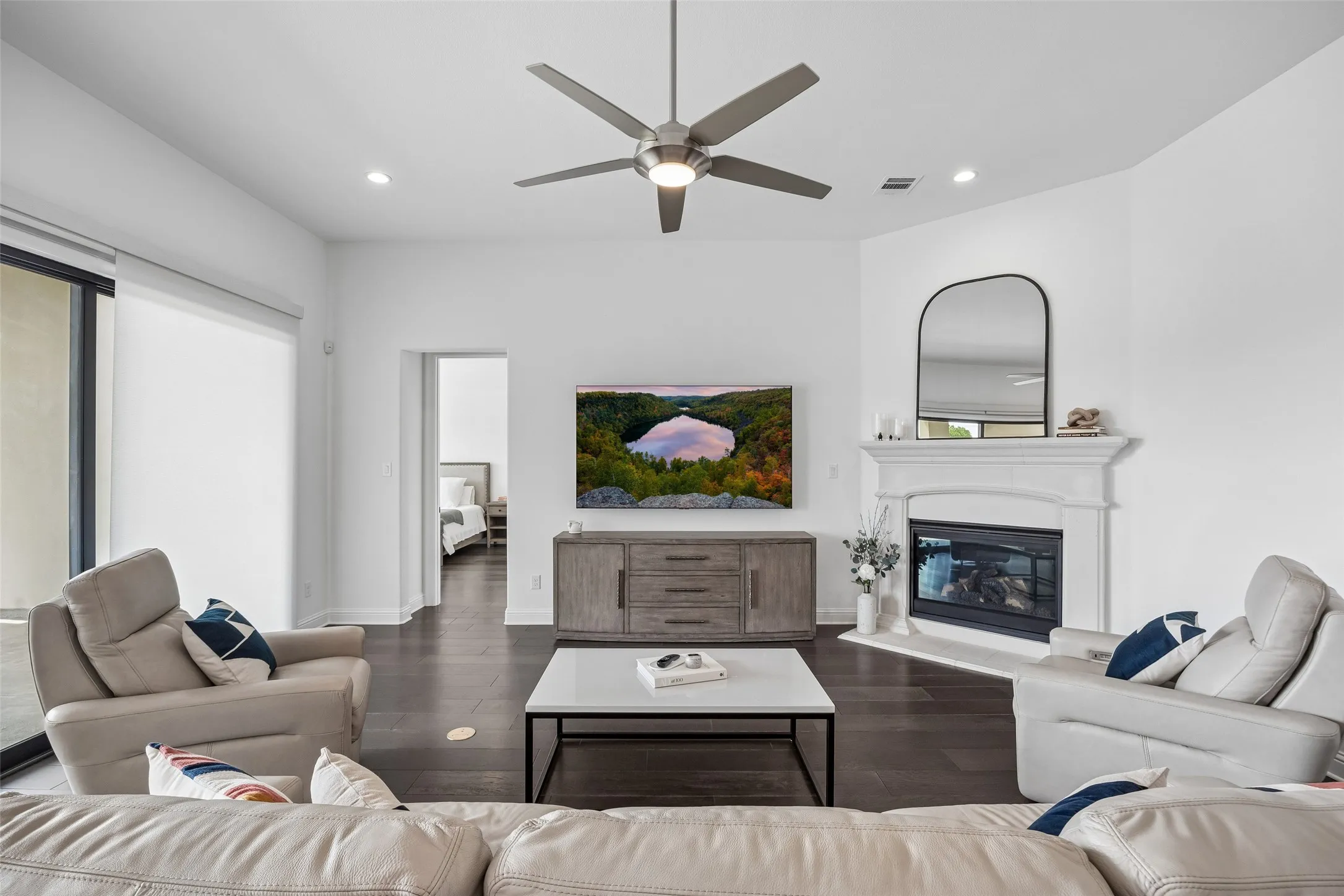 Recessed lighting, dark wood-finish flooring, and a ceiling fan with integrated lighting