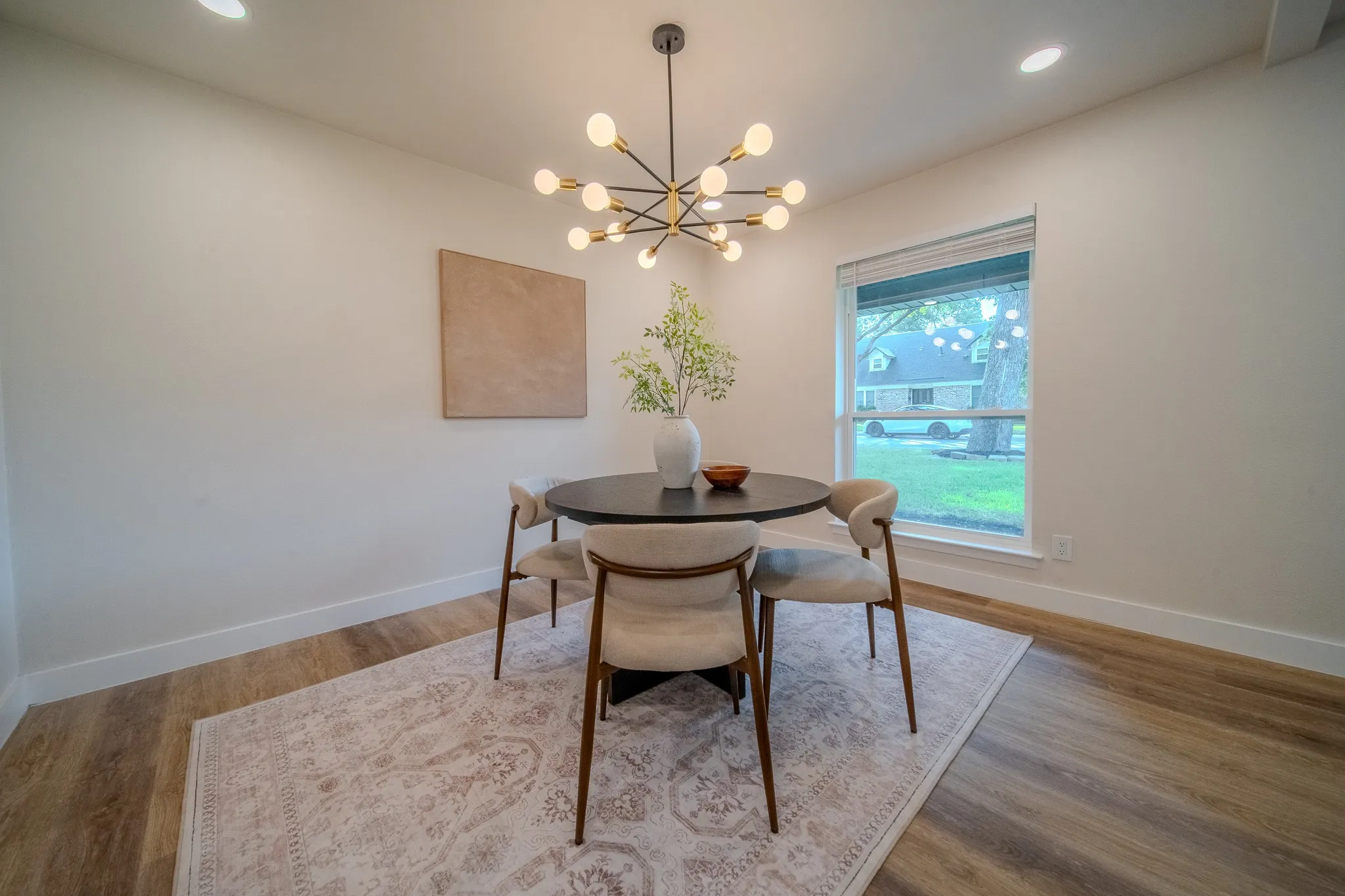 Wood-finish flooring, recessed ceiling lighting, and a contemporary chandelier