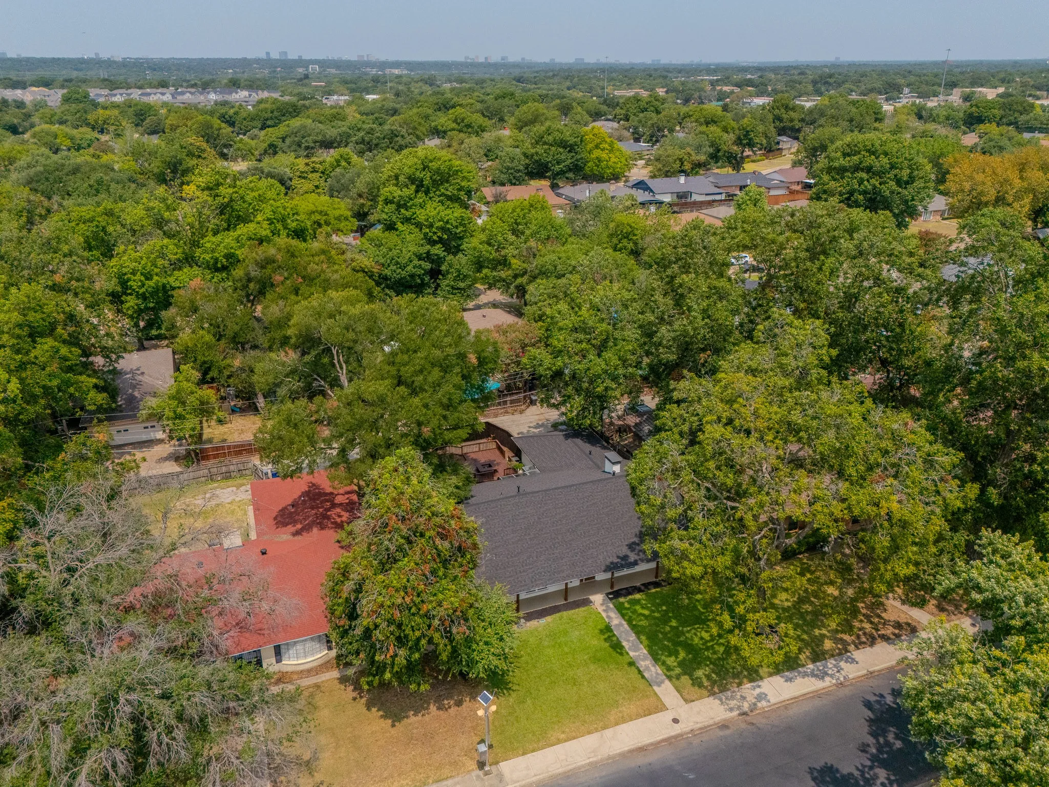 Aerial perspective of a property featuring a red shingle roof and a front lawn