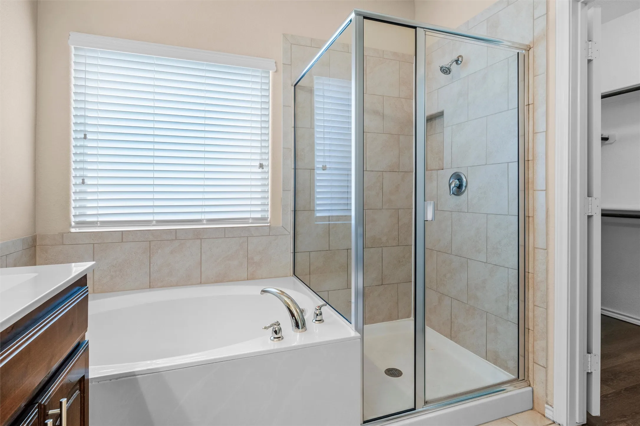Primary ensuite  - Soaking tub with polished chrome fixtures, glass-enclosed shower, and tile surround