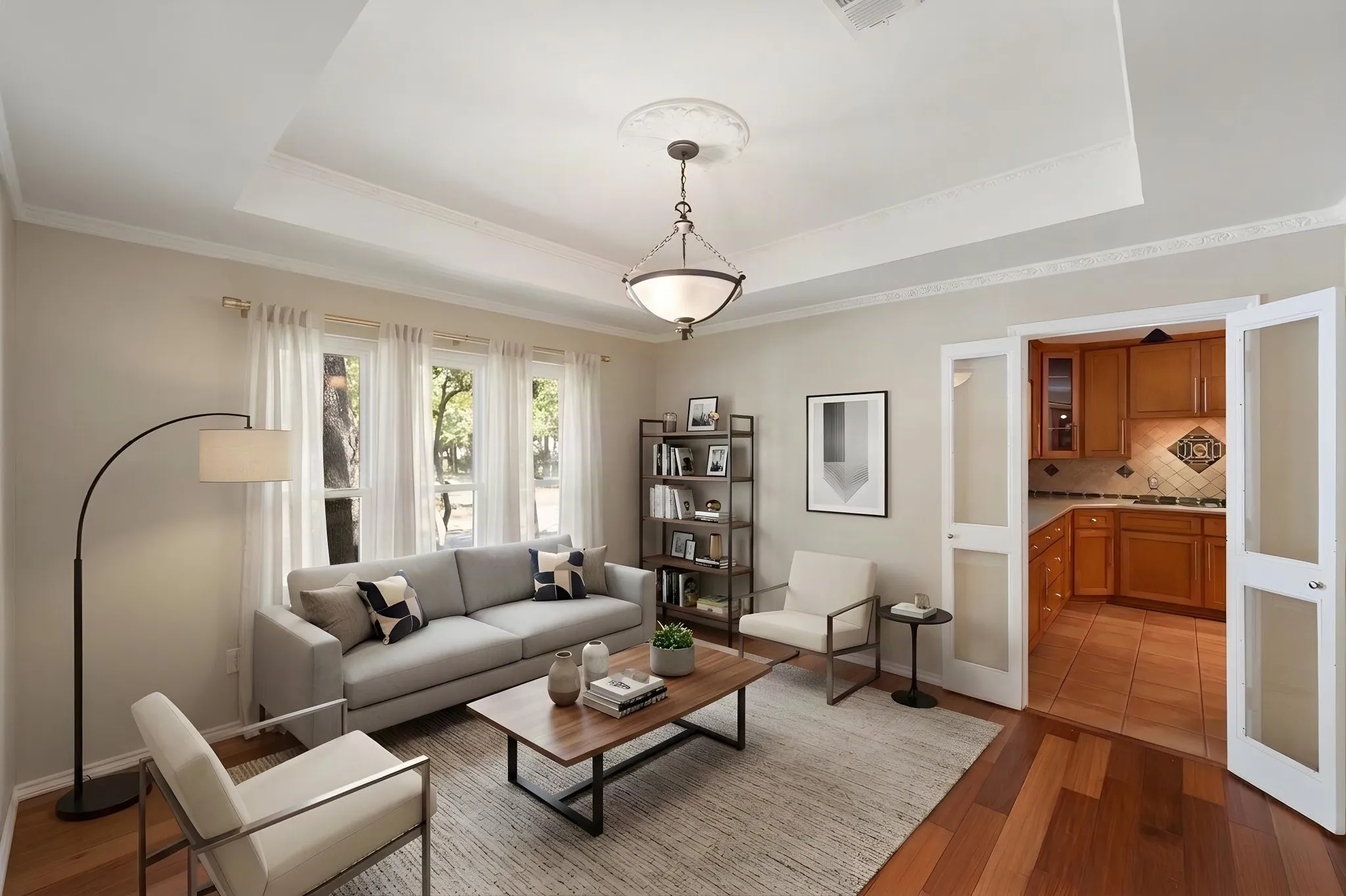 VIRTUALLY STAGED as an office. Tray ceiling with decorative molding, wood-finish flooring, glass-paned double doors, and a built-in kitchen featuring wood cabinetry and tiled backsplash