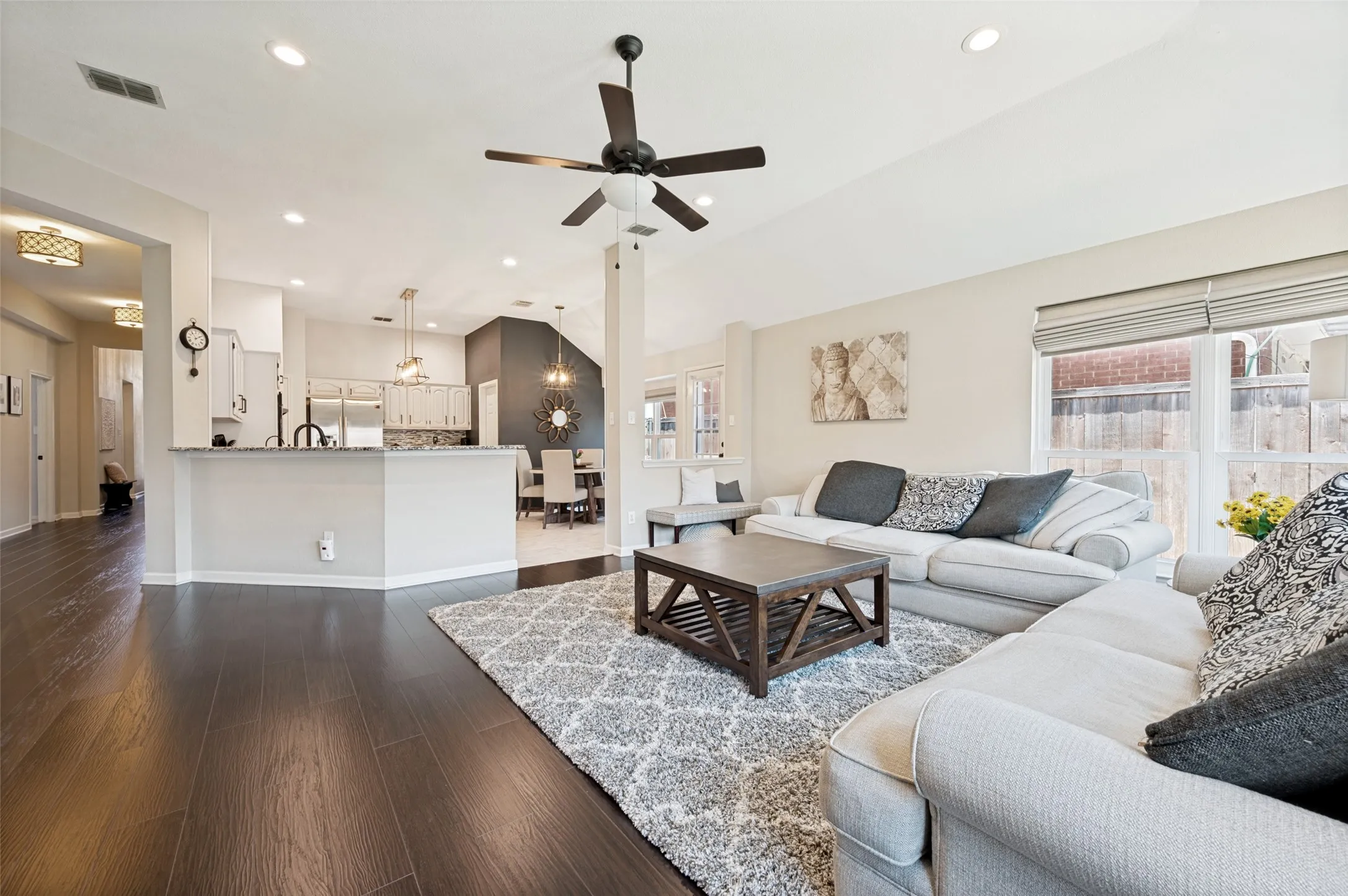 Open-concept living space with dark wood-finish flooring, recessed lighting, and a ceiling fan