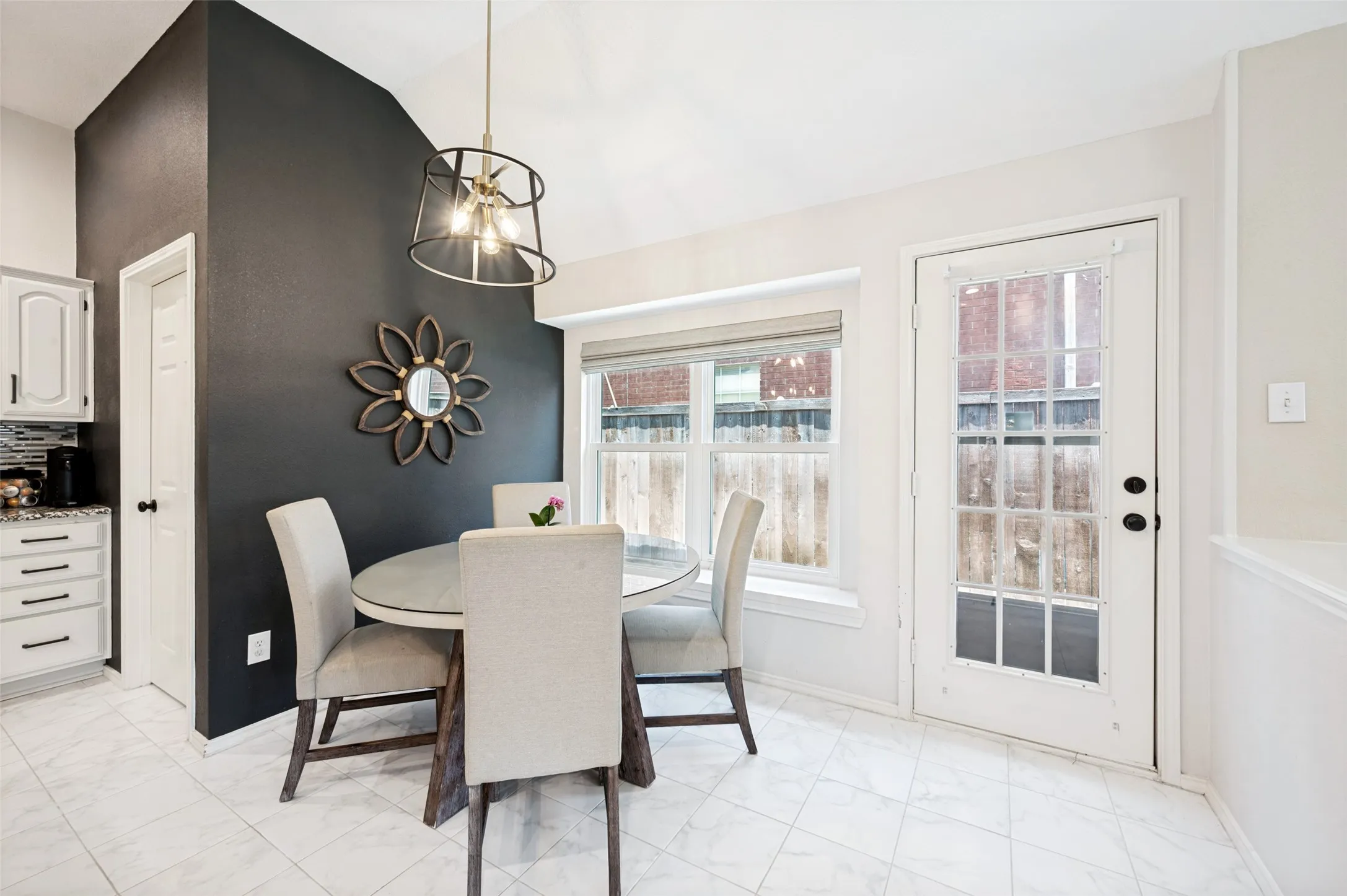 Vaulted ceiling with an industrial-style light fixture, white tile flooring, and a glass-paned door