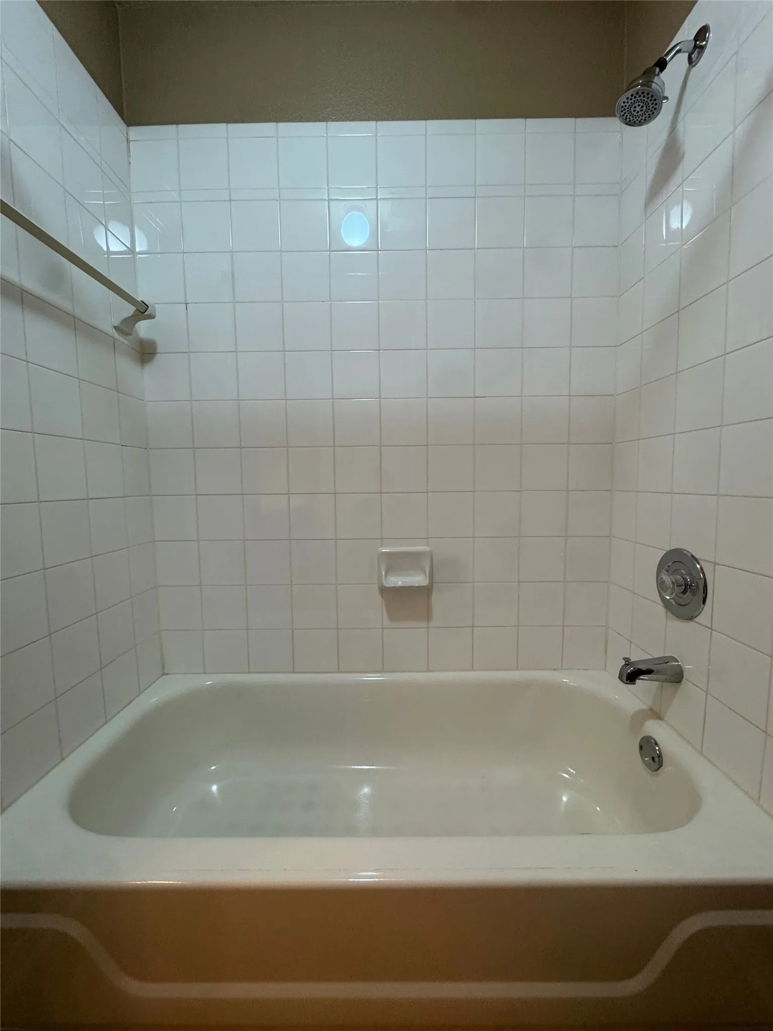 White tiled shower surround with a built-in soap dish