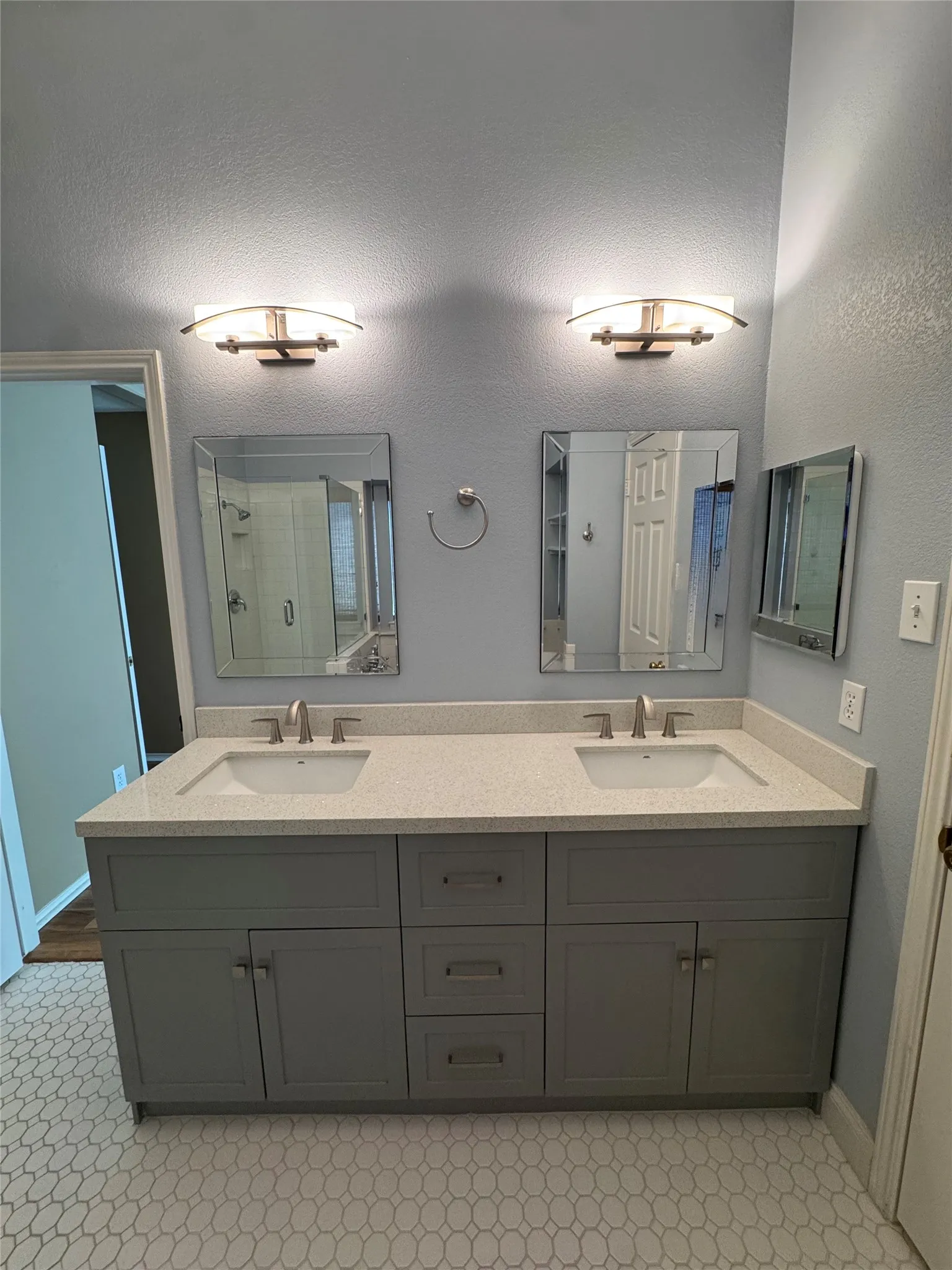 Dual vanity with light gray cabinetry and white countertops