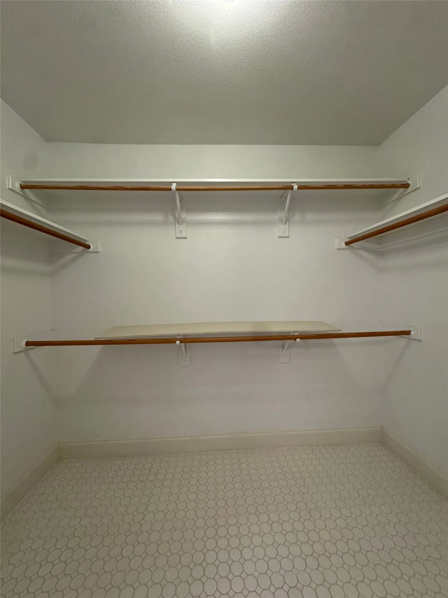 White walls with two levels of integrated shelving and hanging rods