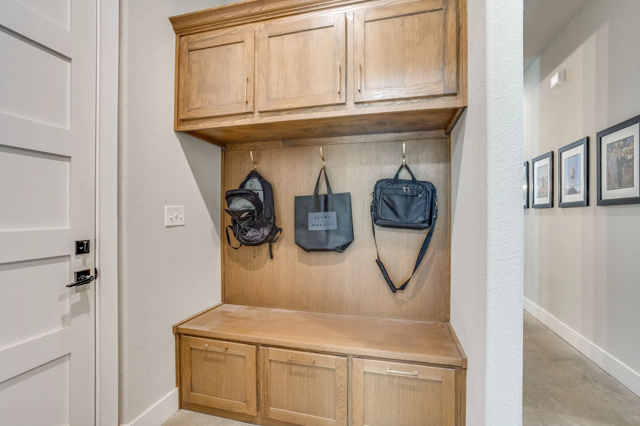 Built-in wood-finish cabinetry, integrated bench seating, and wall-mounted hooks