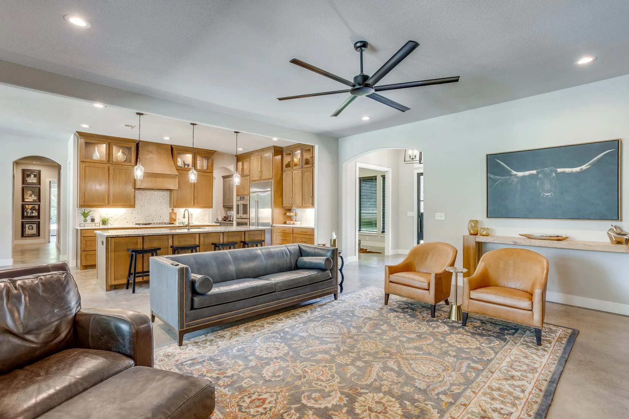 Open-concept living space featuring high ceilings, recessed lighting, and a large ceiling fan