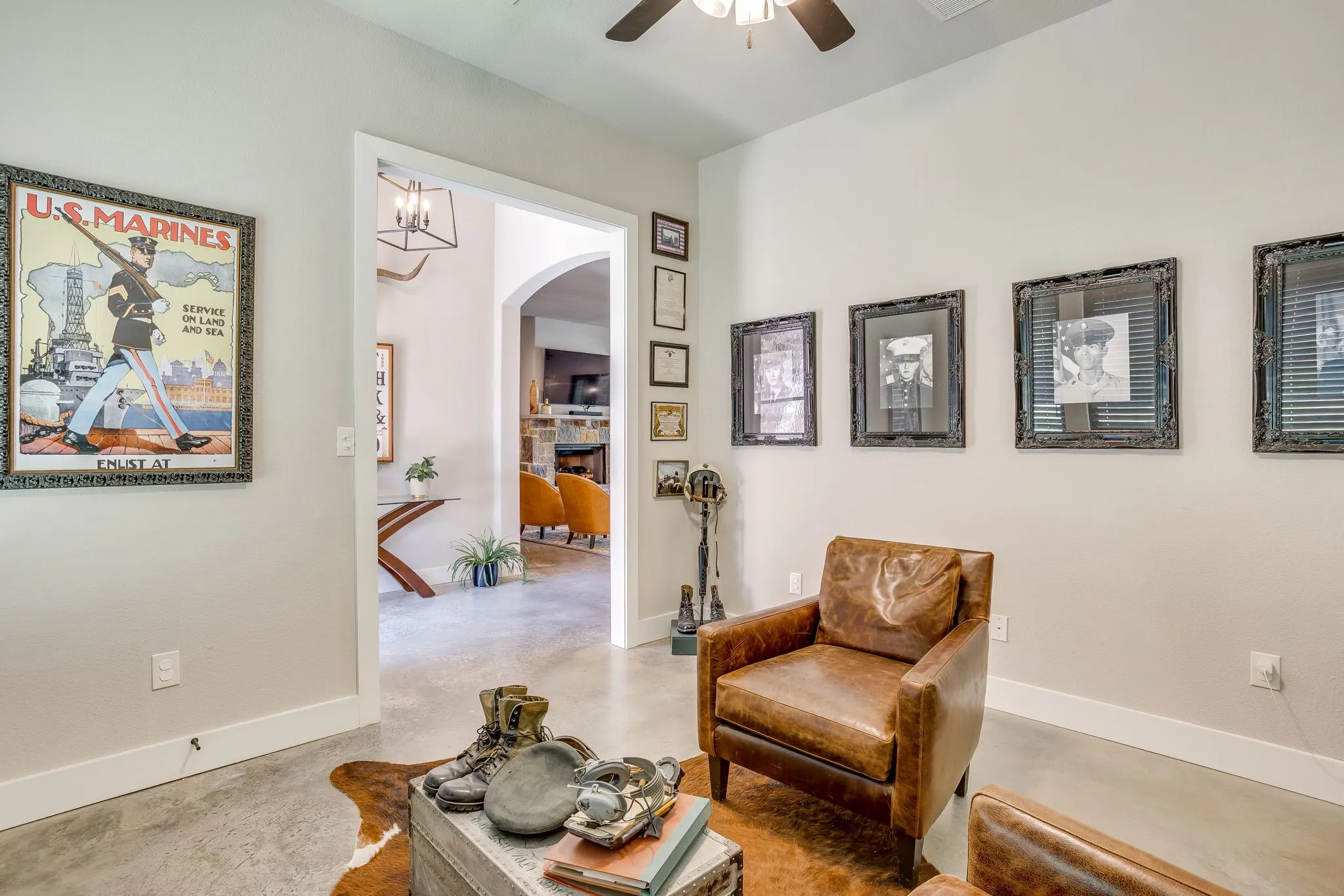 Office/Study with neutral wall paint and white trim, concrete flooring, and an arched doorway