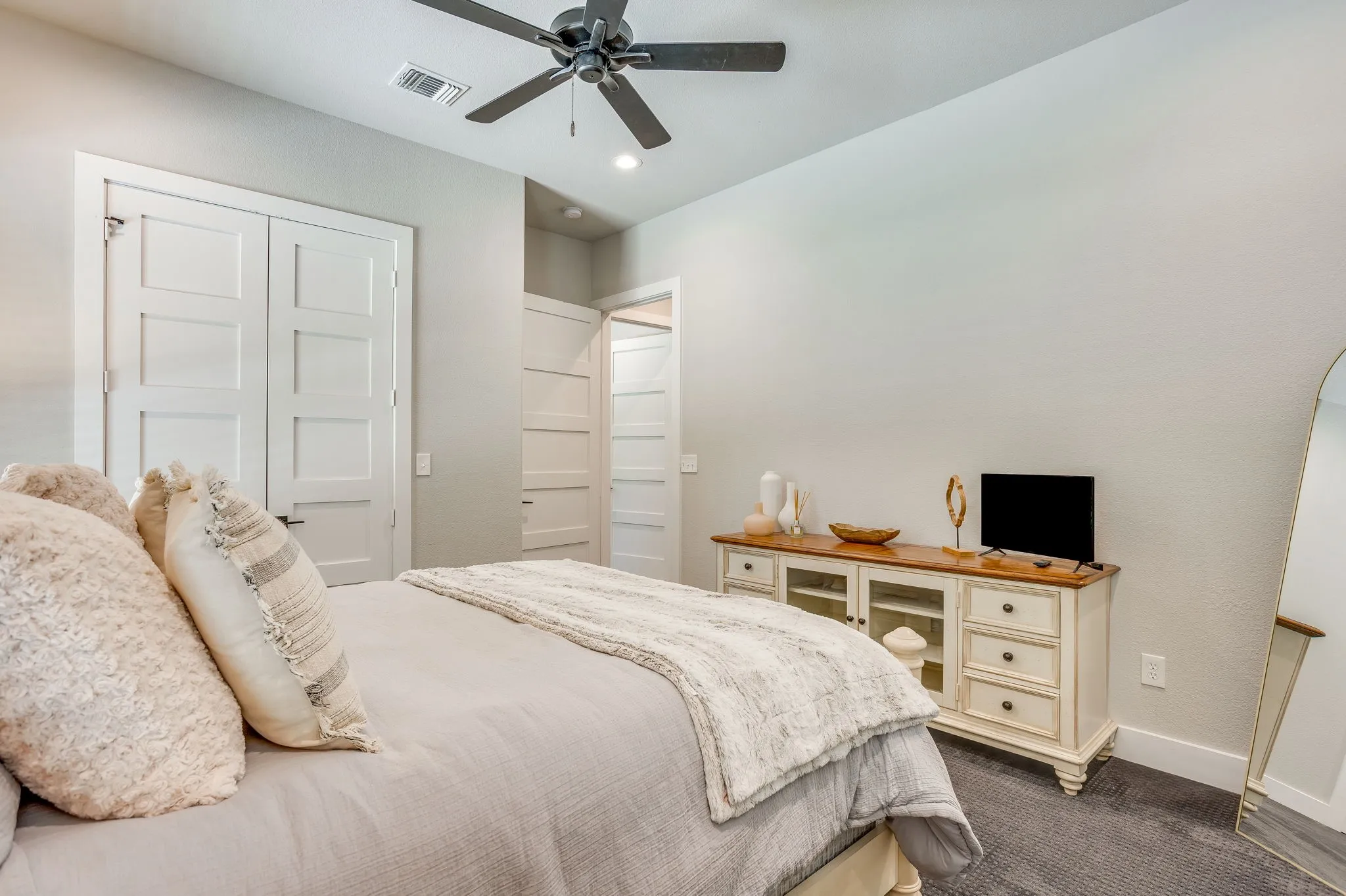 Ceiling fan with dark-toned blades, white paneled closet doors, and white paneled interior doors