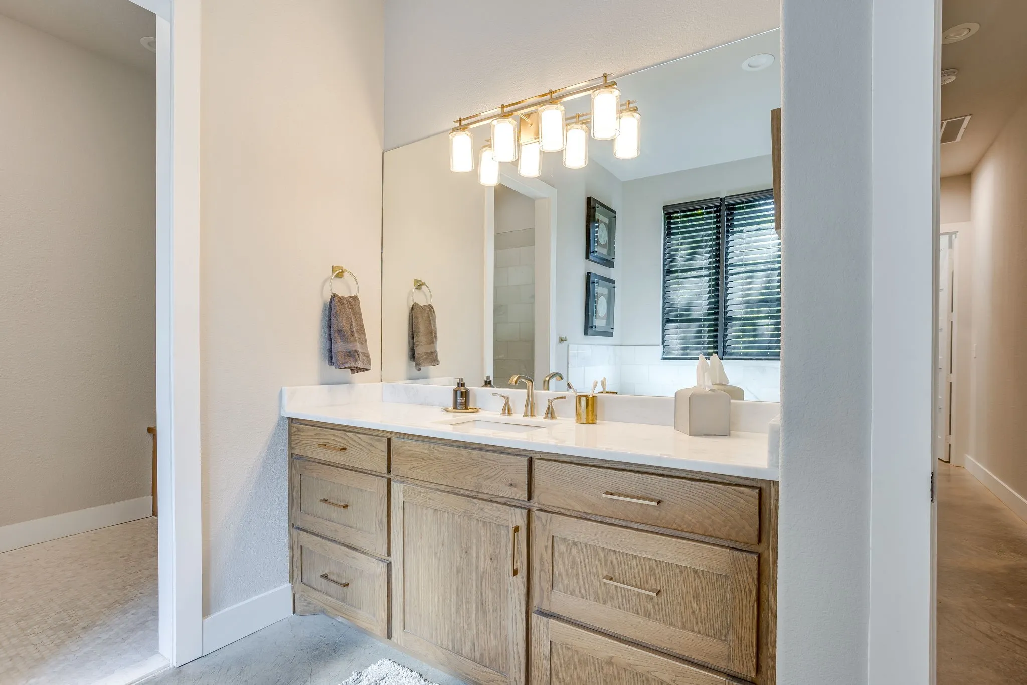 Wood-finish vanity with drawer storage, white countertop, and rectangular undermount sink