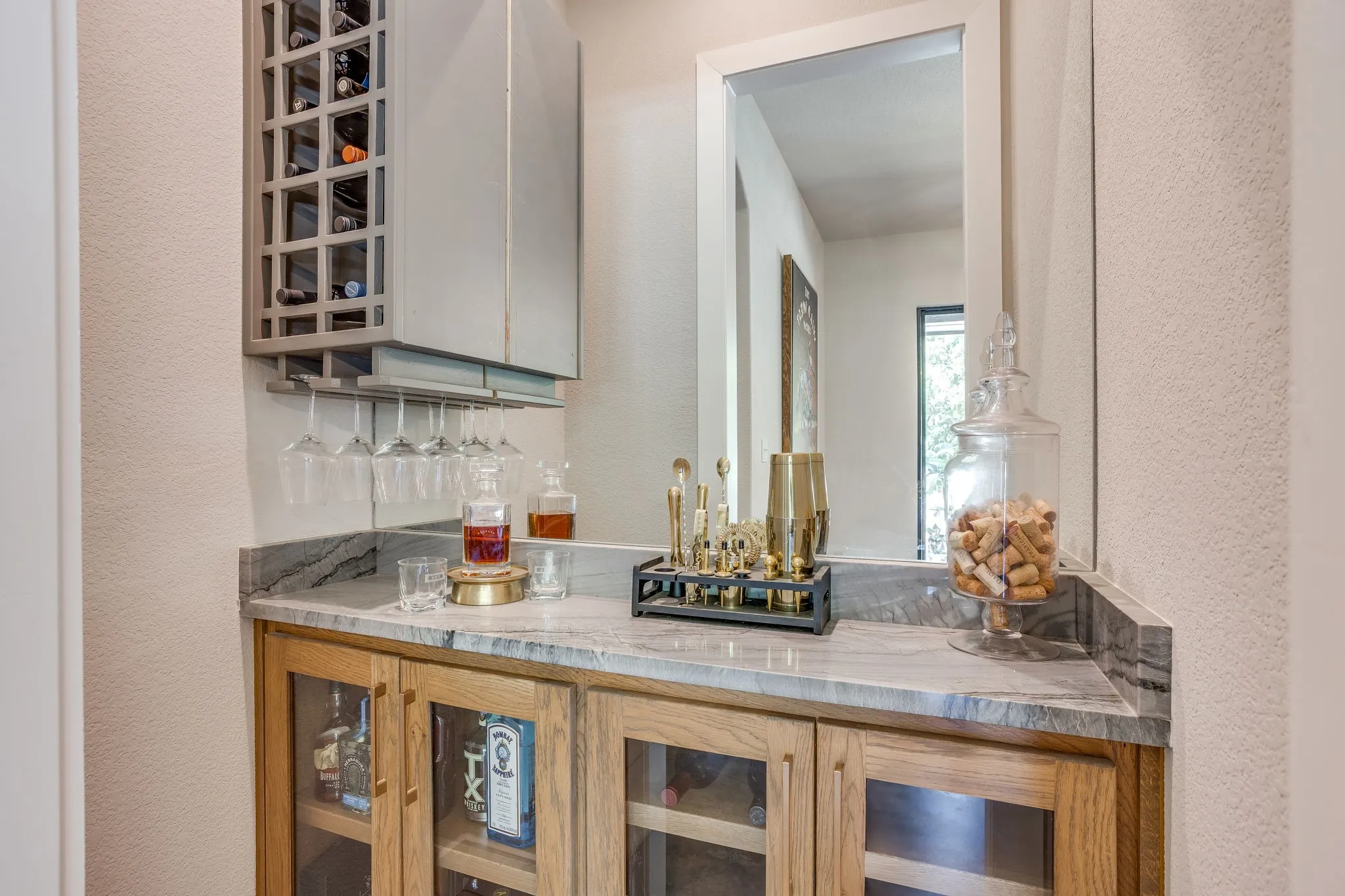 Custom built-in bar featuring a stone countertop, glass-front cabinetry, an integrated wine rack, and stemware storage