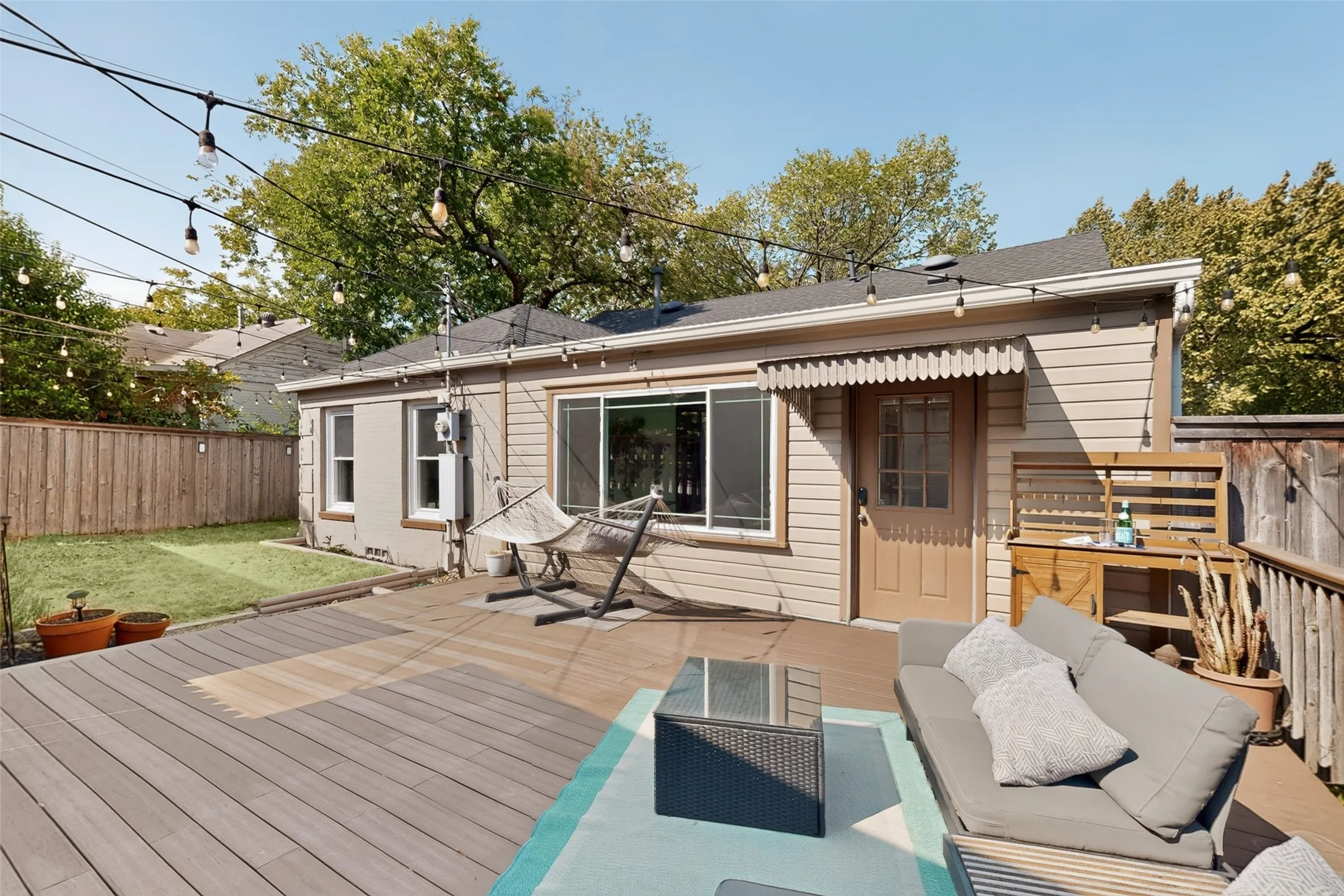 Your cozy backyard with tall wood privacy fence and trax decking that is easy on your feet and needs virtually no maintenance.
