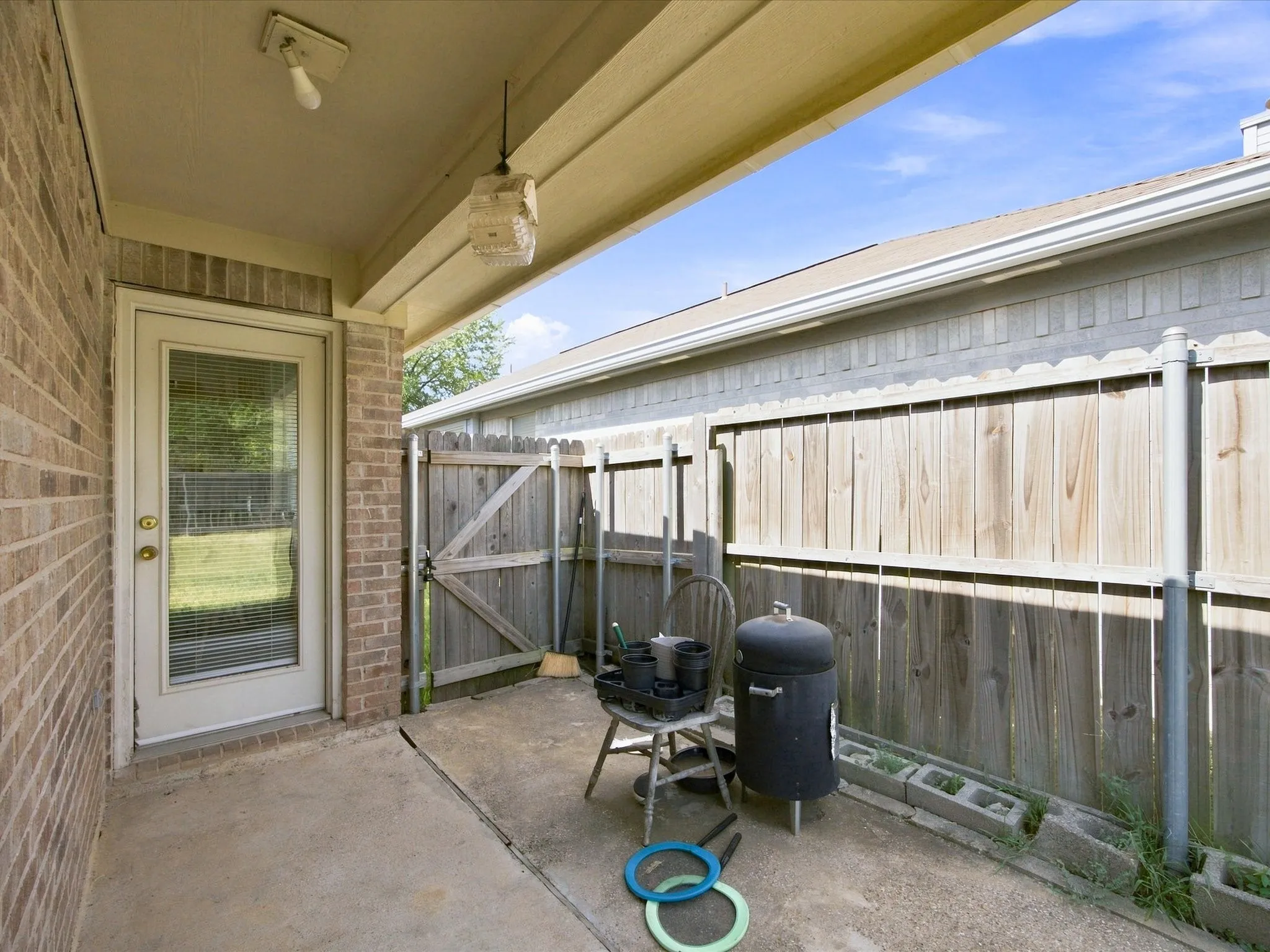 Covered concrete patio with brick-clad exterior
