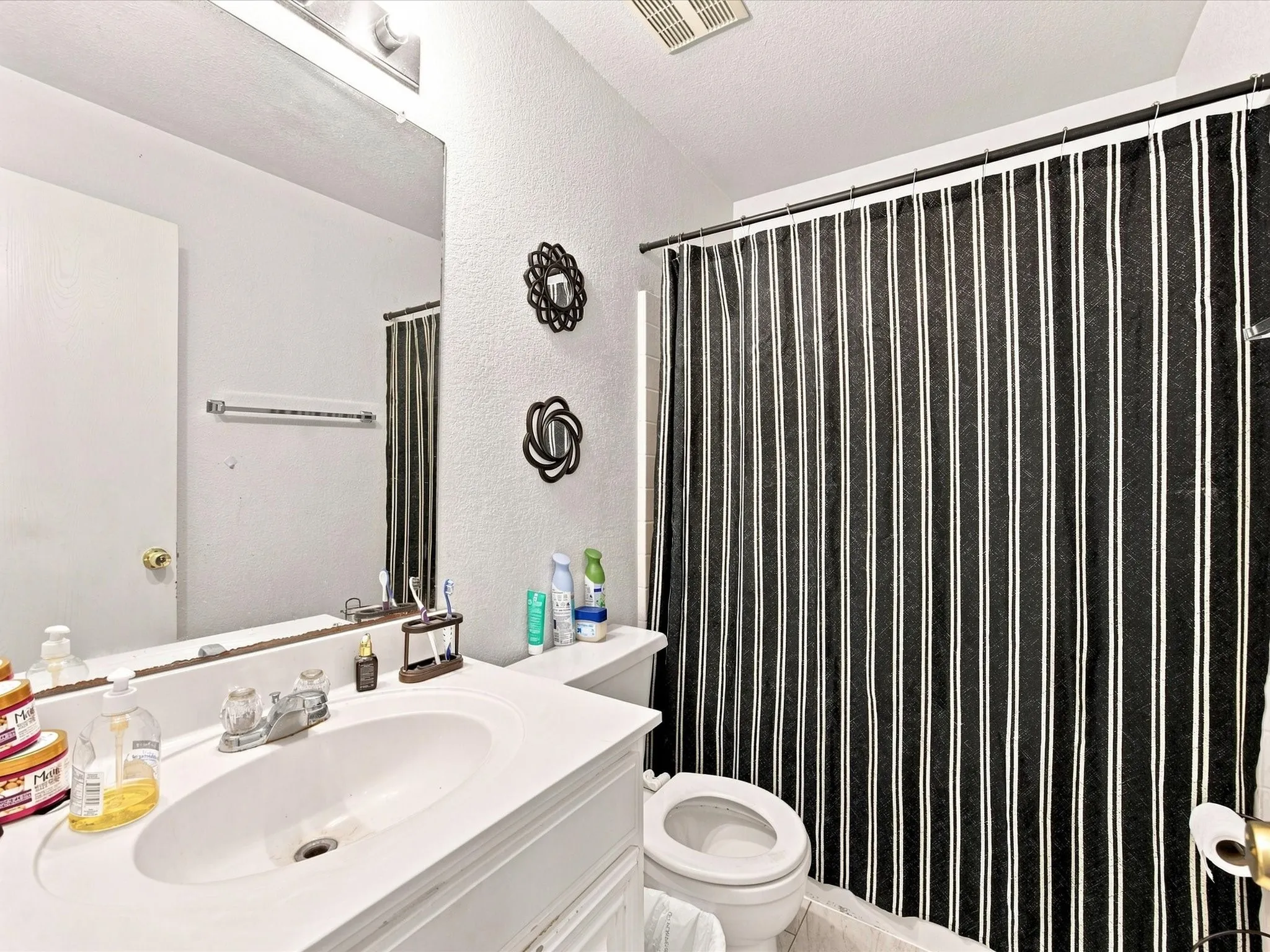 White single-sink vanity with an integrated basin, chrome faucet, and expansive wall mirror