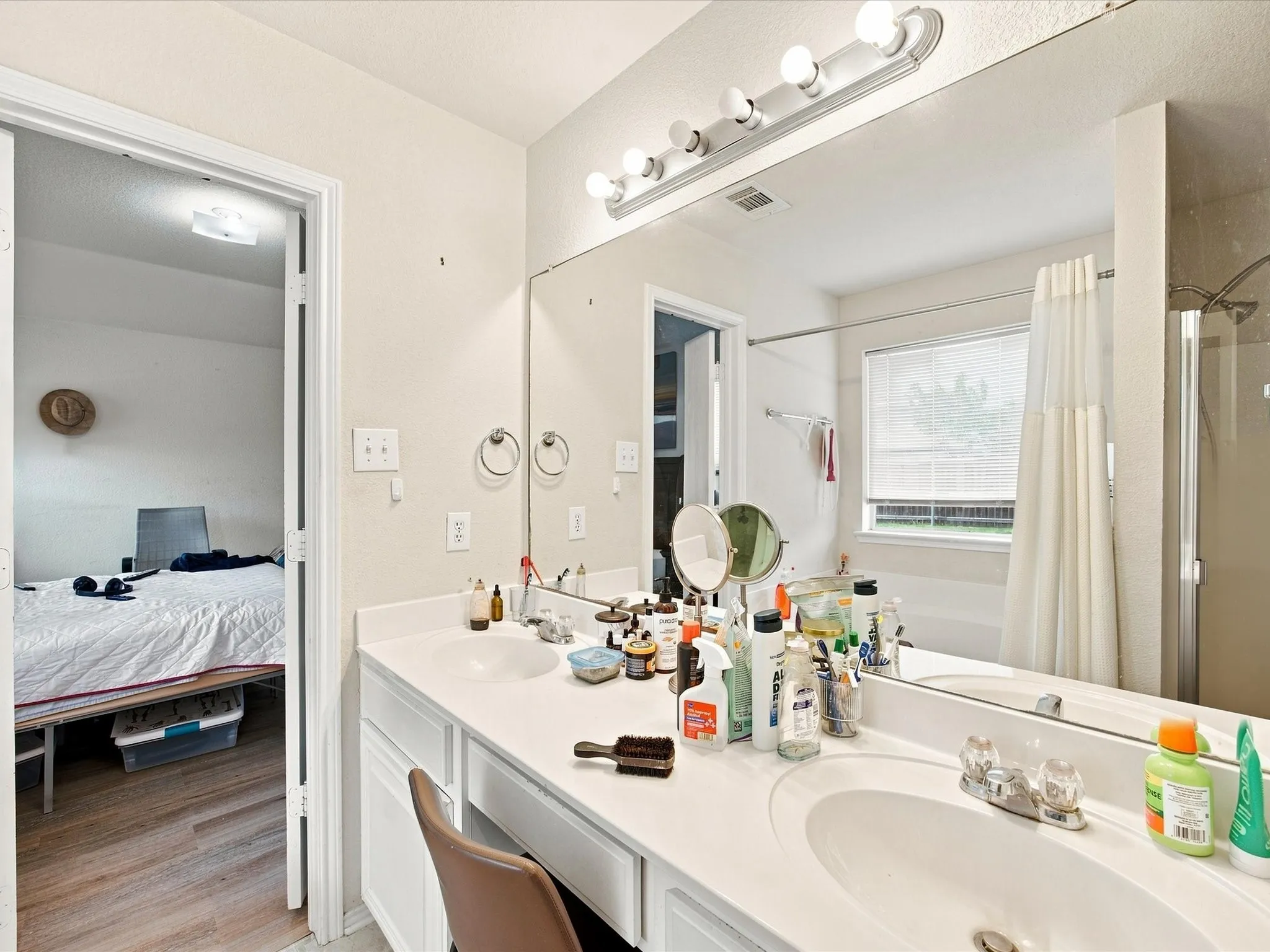 Double vanity with integrated sinks, large wall mirror, and vanity lighting
