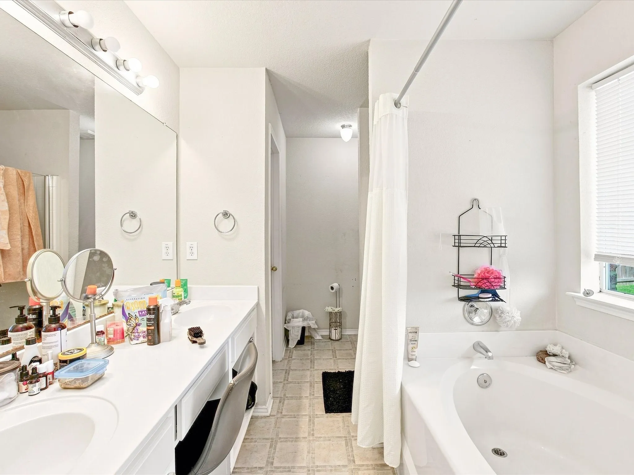 Double vanity with integrated sinks, large wall mirror, and overhead vanity lighting