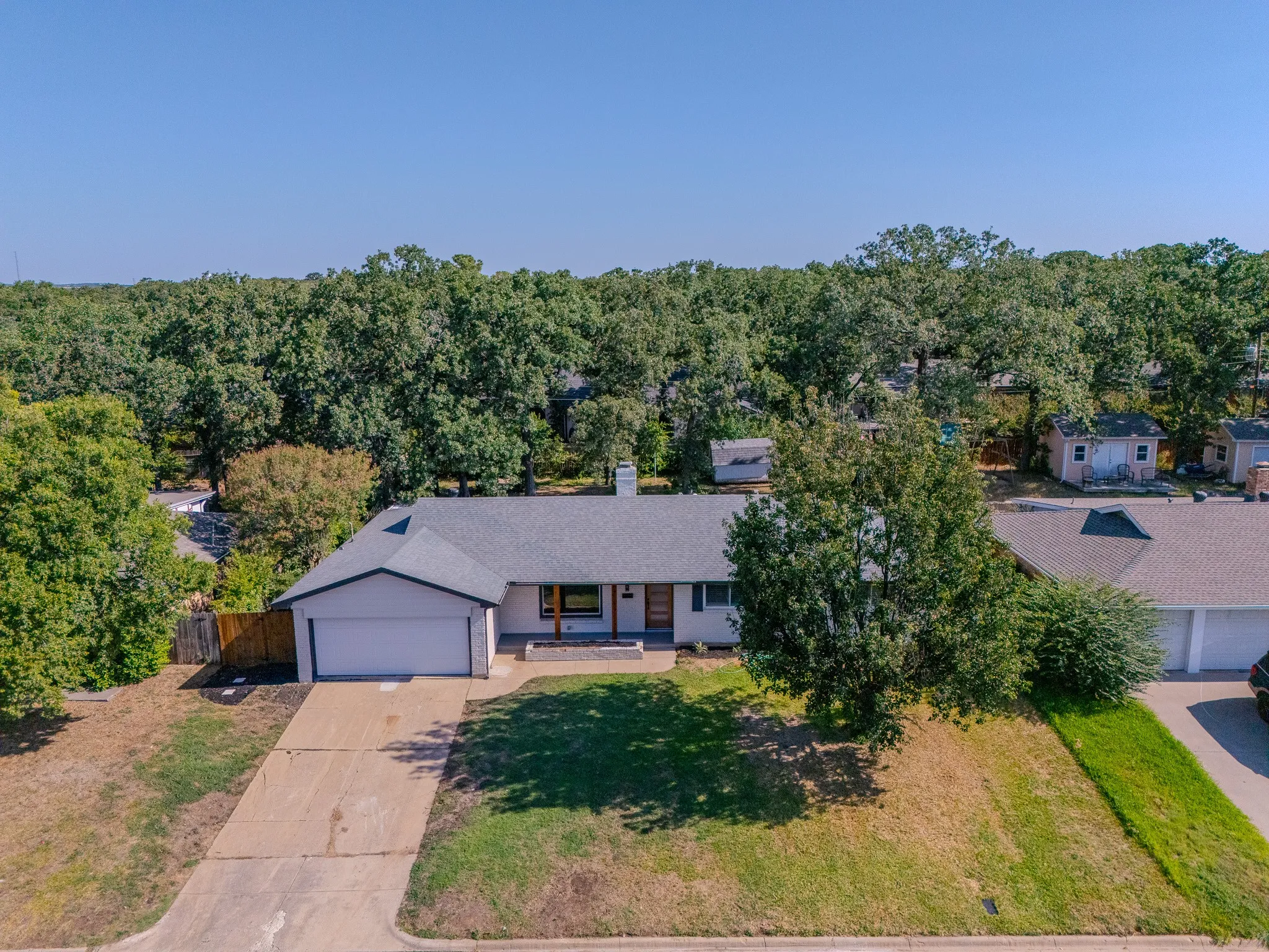 Single-story residence featuring an attached garage, a neutral exterior color palette, and a gray shingled roof