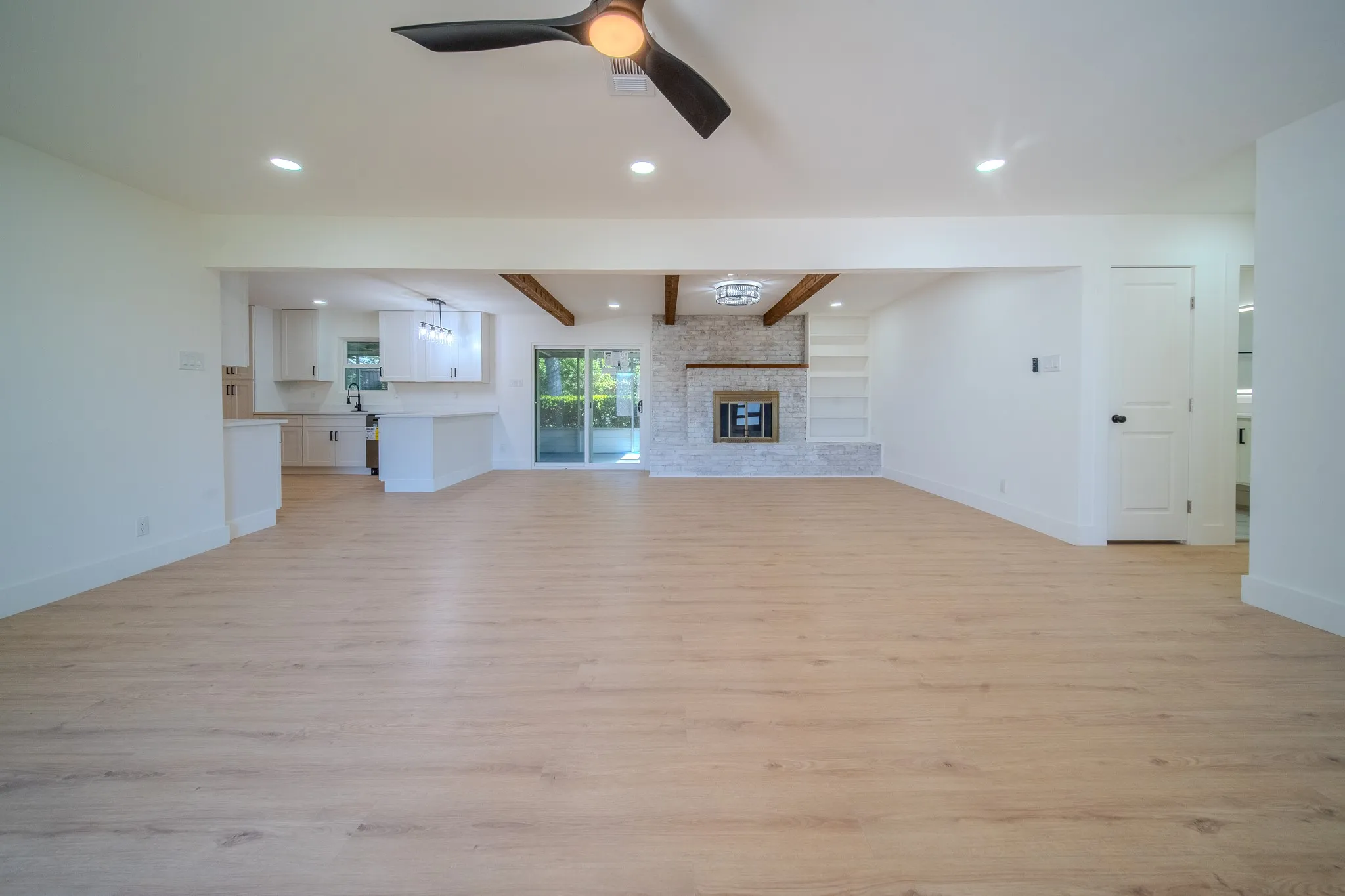 Open-concept living area with wood-finish flooring, recessed lighting, and a modern ceiling fan
