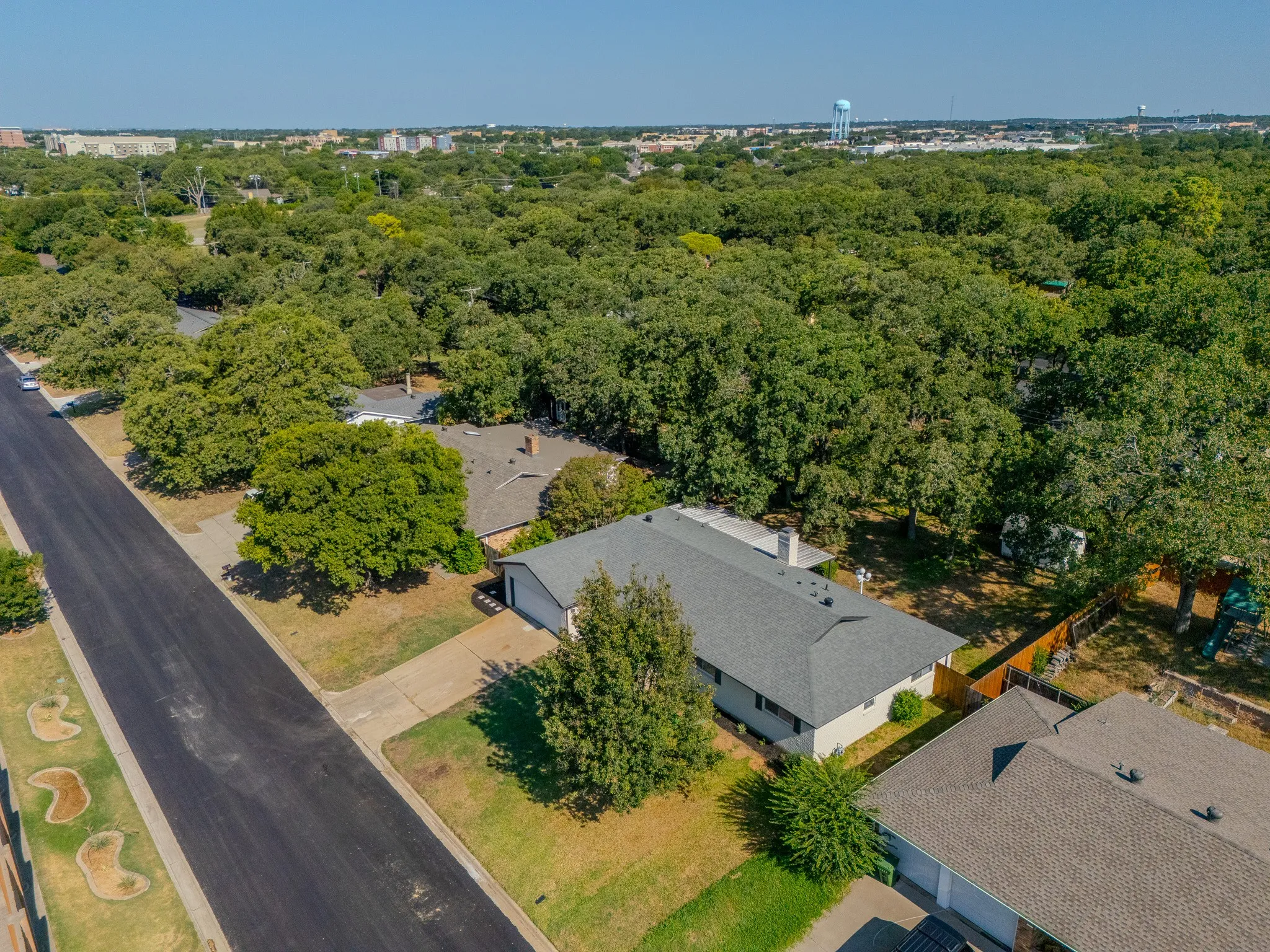 Single-story residence with a gray shingle roof and a concrete driveway