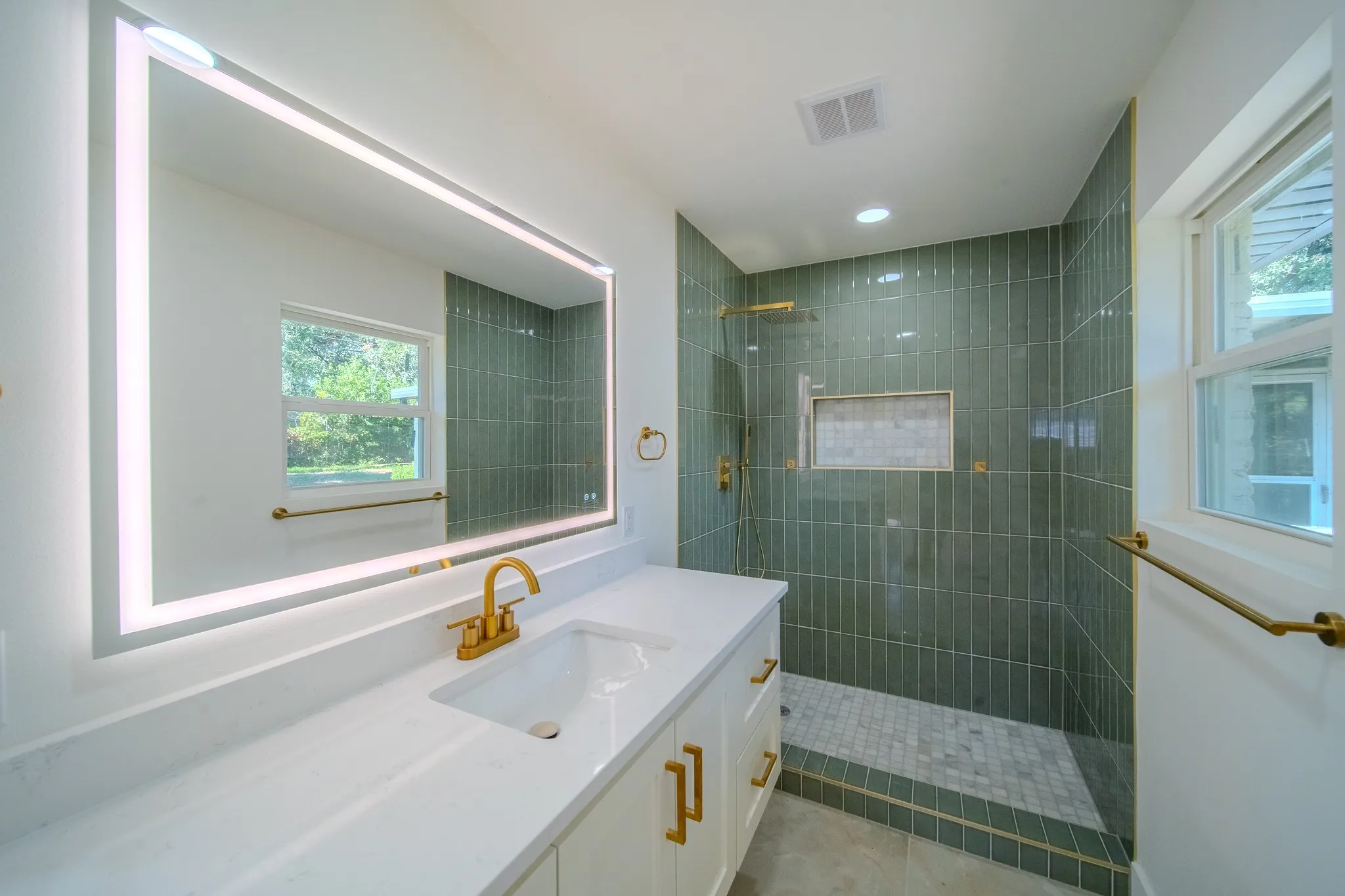 Vanity with a quartz countertop, integrated sink, and brass-finish hardware
