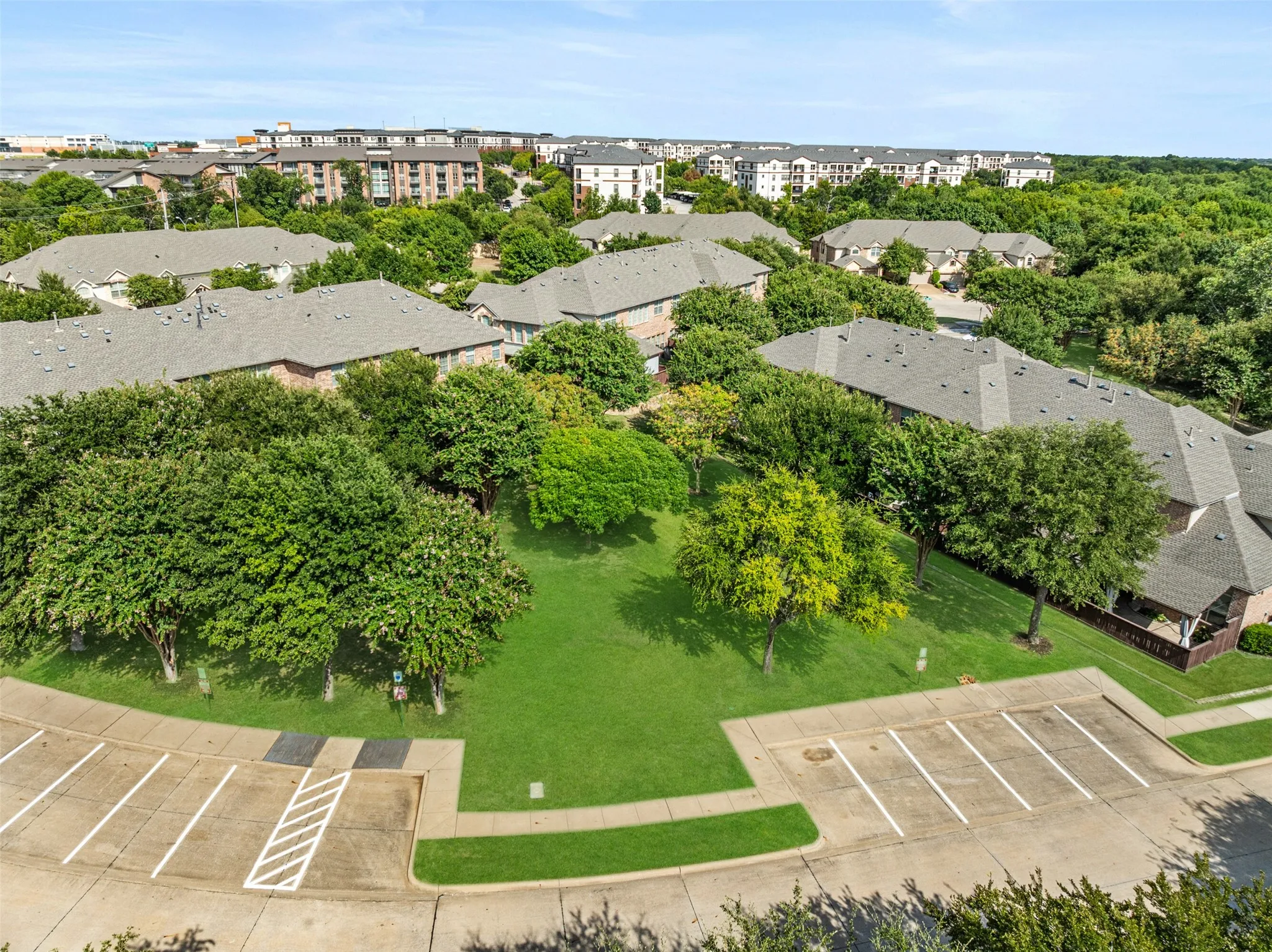 Aerial view of green space behind the home. Also, note the abundance of parking available for guests