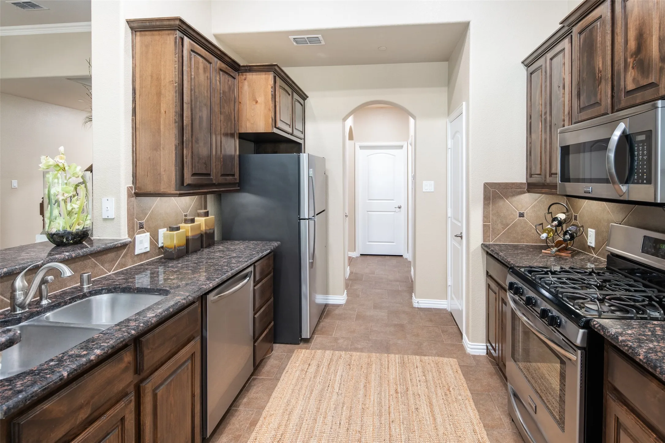 Kitchen has stainless appliances, gas cooking, microwave and refrigerator