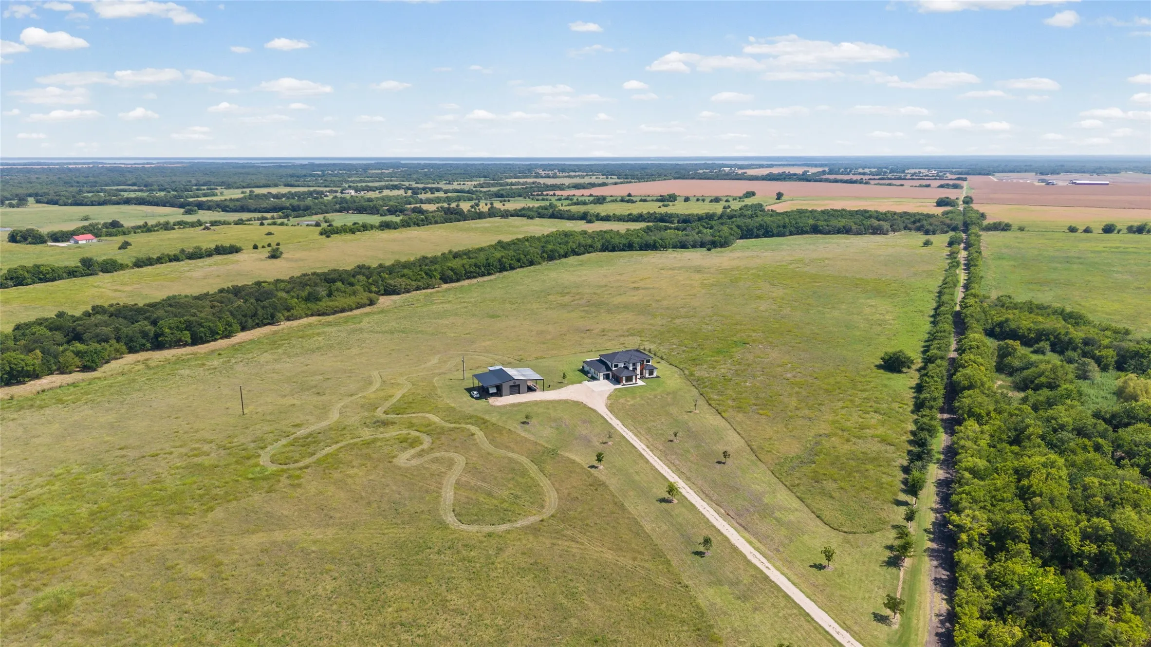 Spacious grounds with a private driveway, a two-story residence, a detached auxiliary building, and extensive surrounding green space