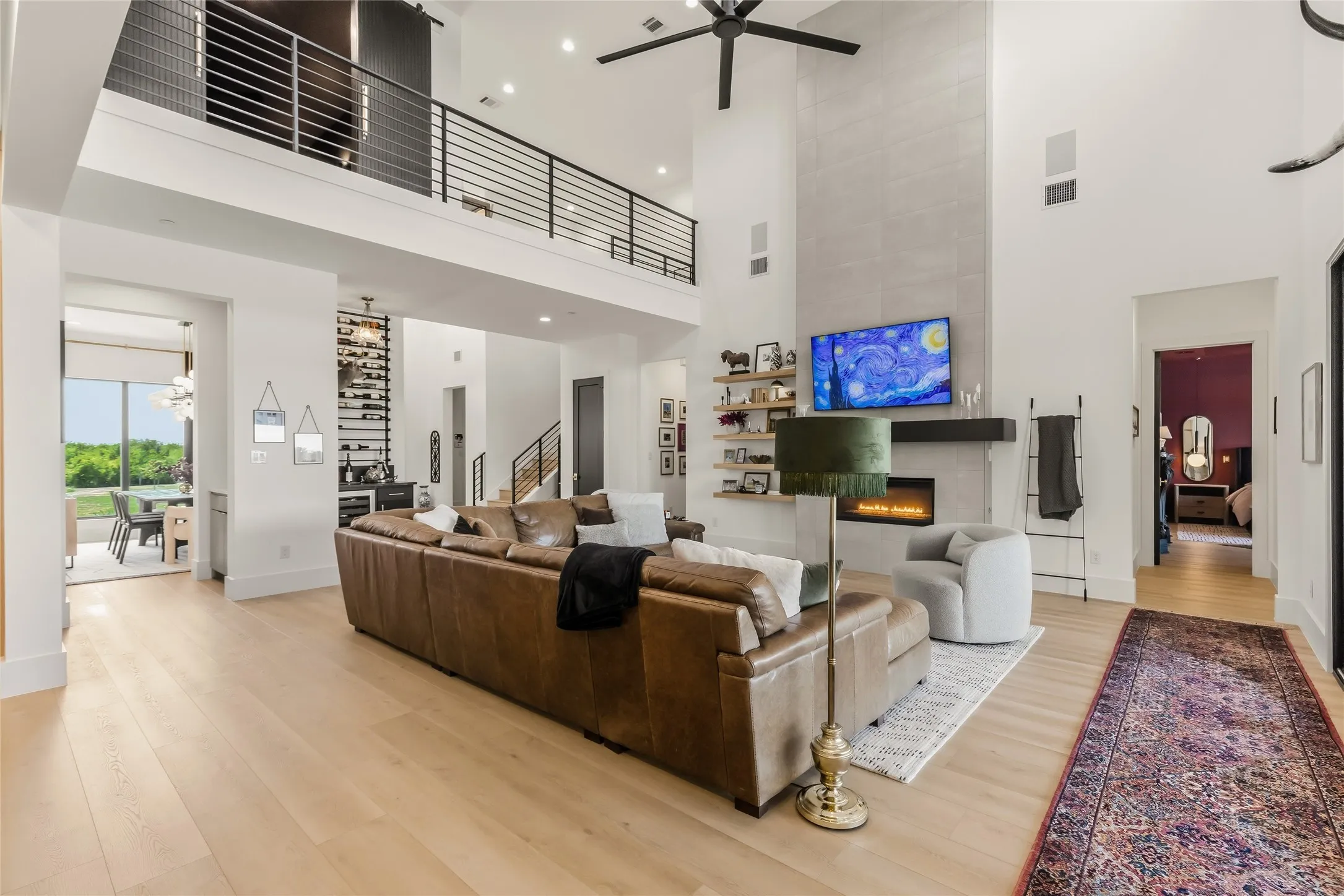 Double-height living area featuring a fireplace with floor to ceiling tile and a custom black metal mantel
