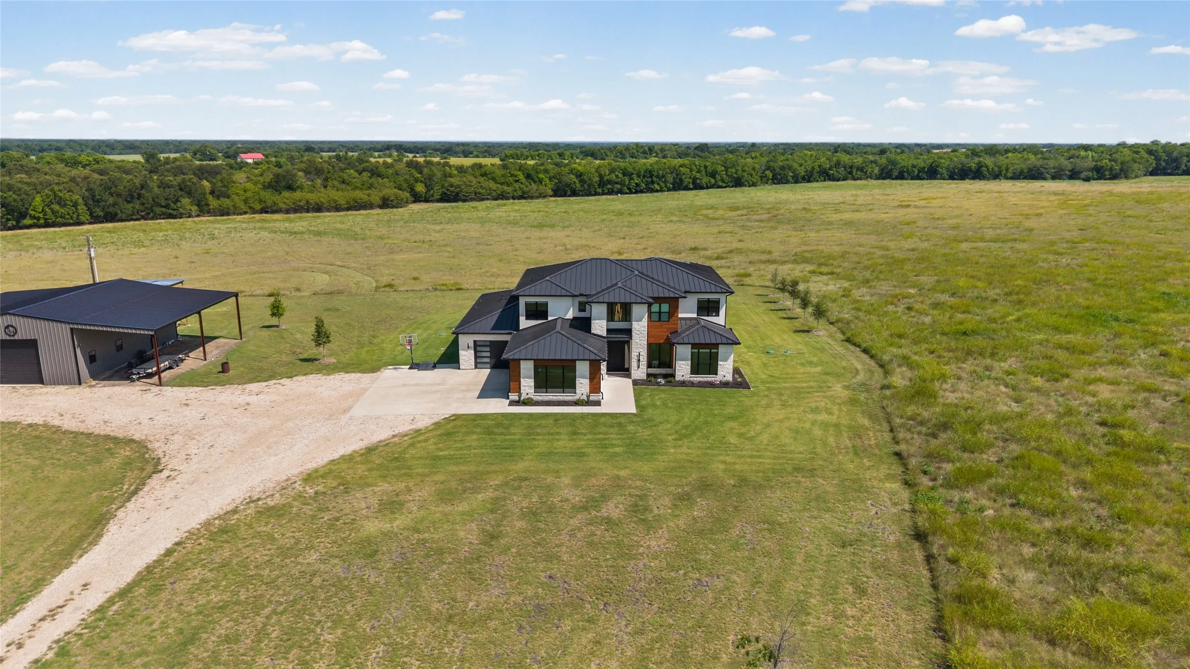 Modern two-story residence with a black standing seam roof and two attached garages