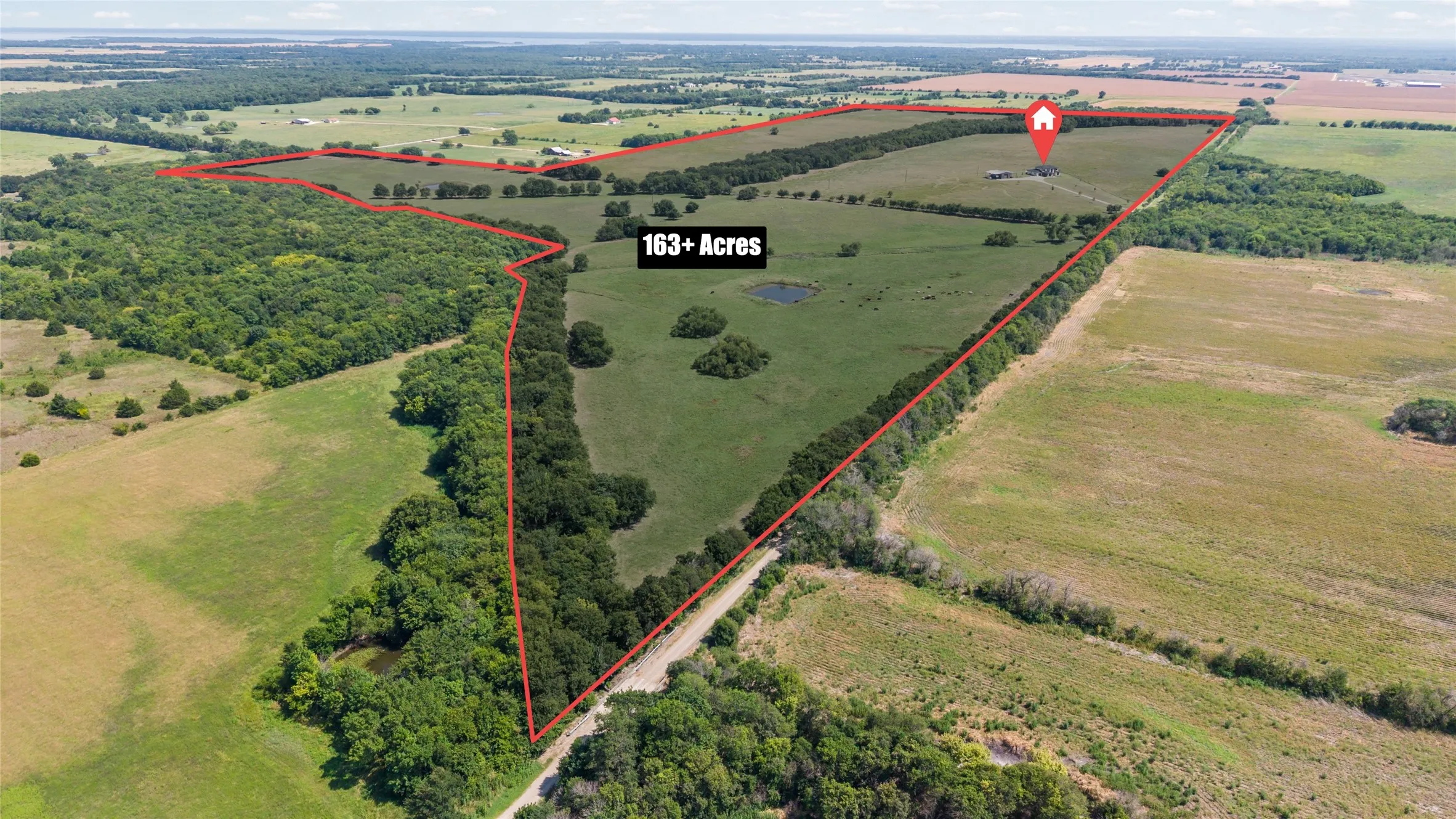 Expansive 163+ acre rural property featuring a mix of open fields and mature tree lines