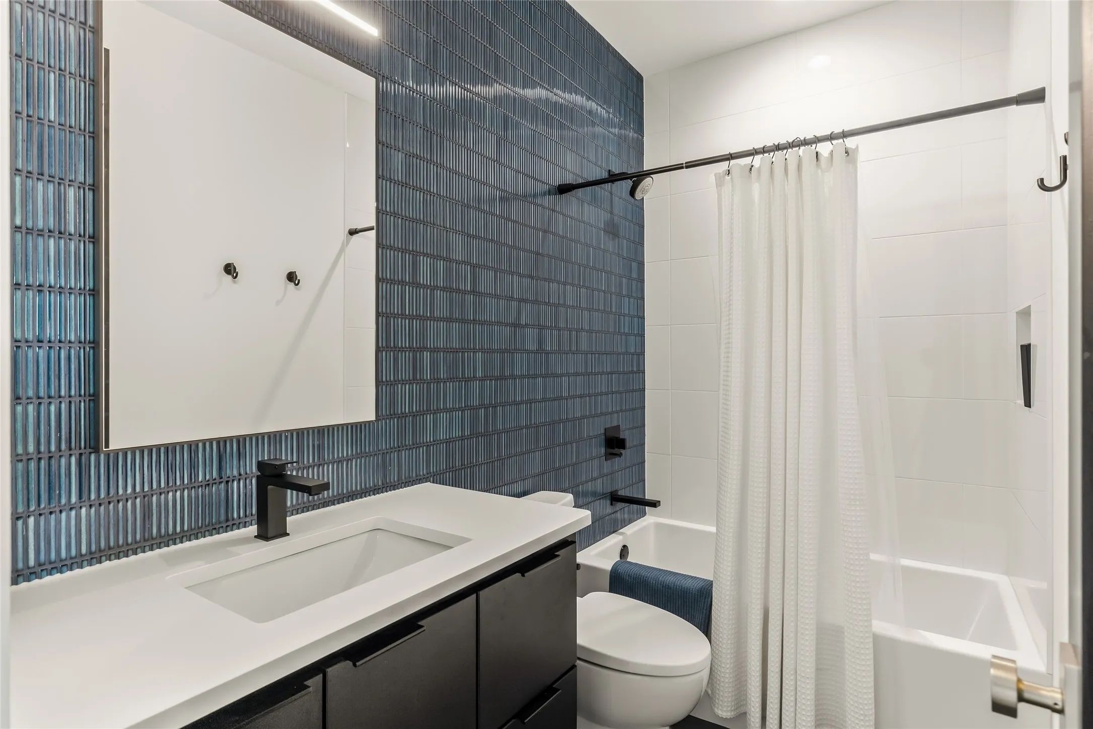 Vanity with integrated sink, matte black faucet, and sleek black cabinetry